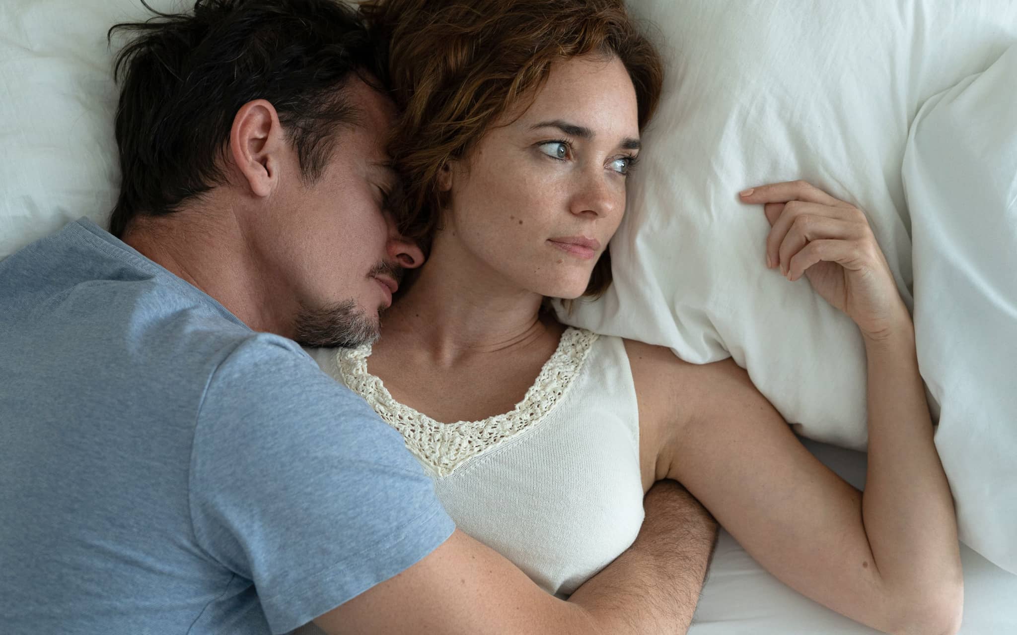 Dyspareunie: Ein Paar ist intim, die Frau guckt nachdenklich