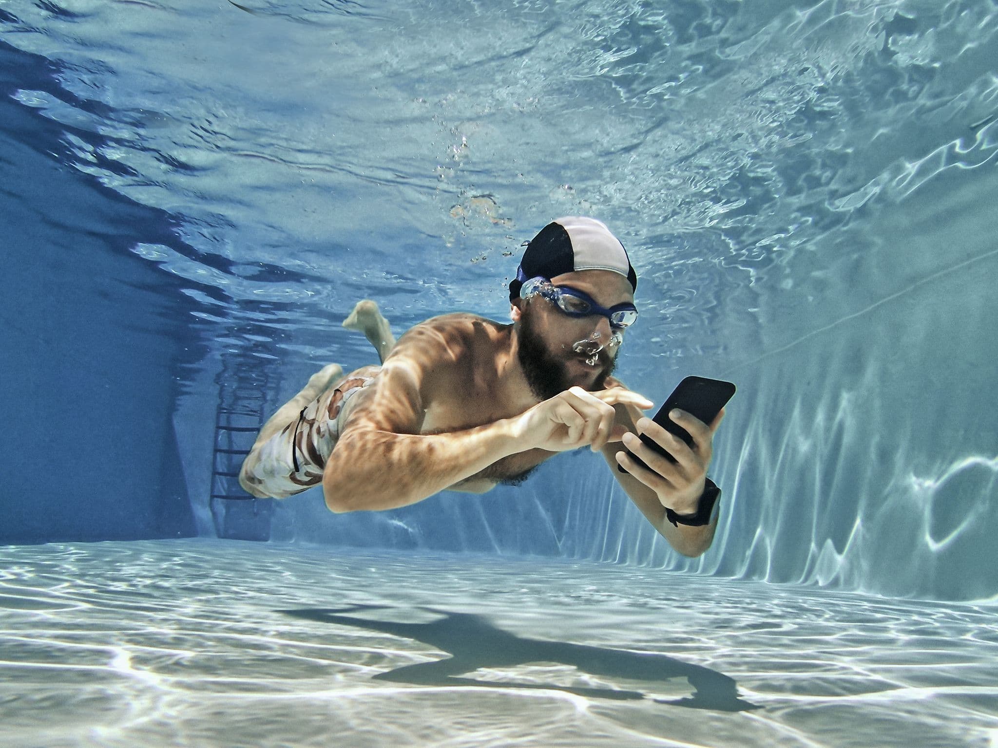 Schwimmer mit Handy unter Wasser