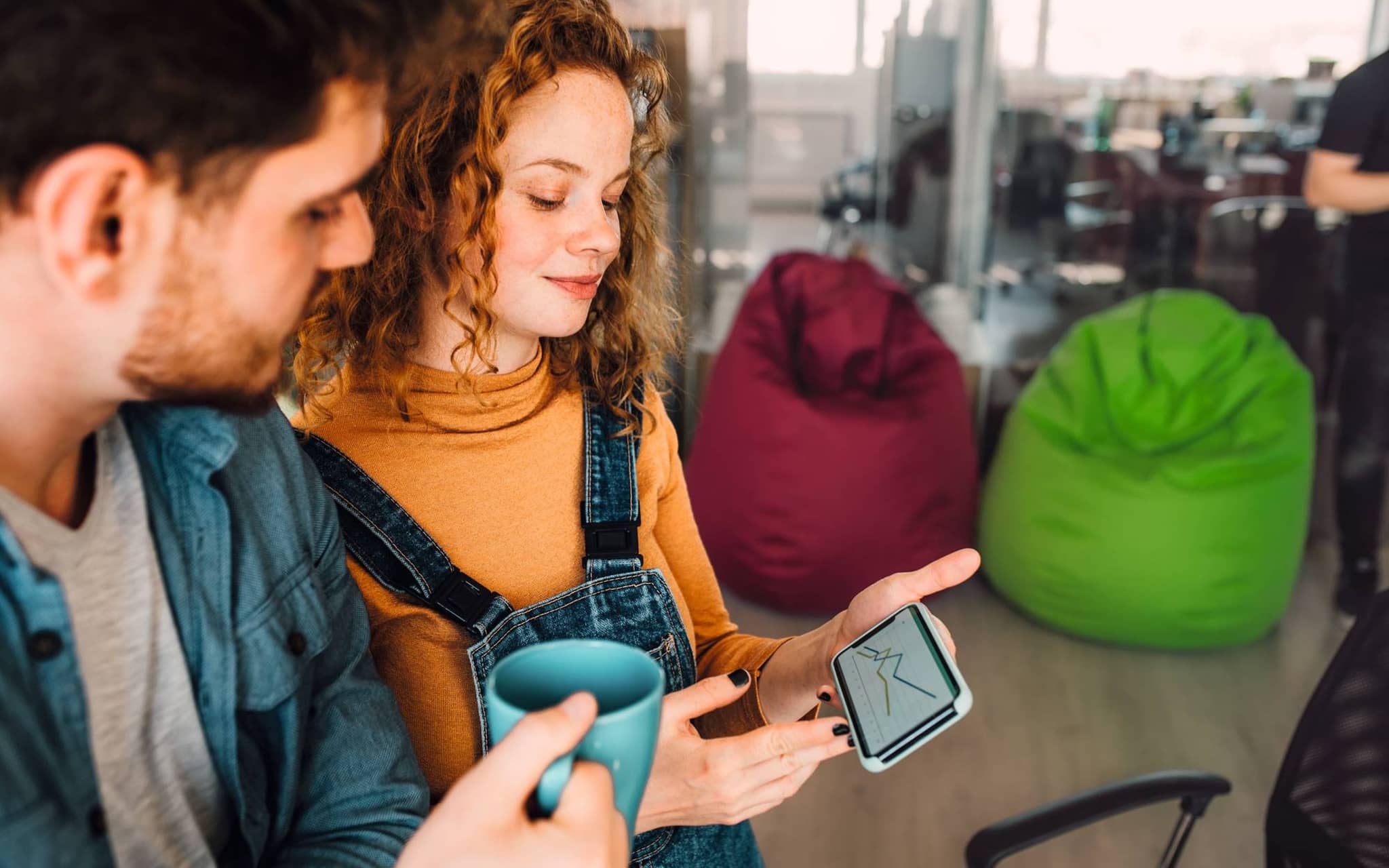 Zwei Mitarbeitende freuen sich, über die positiven Auswirkungen des Betrieblichen Gesundheitsmanagements.