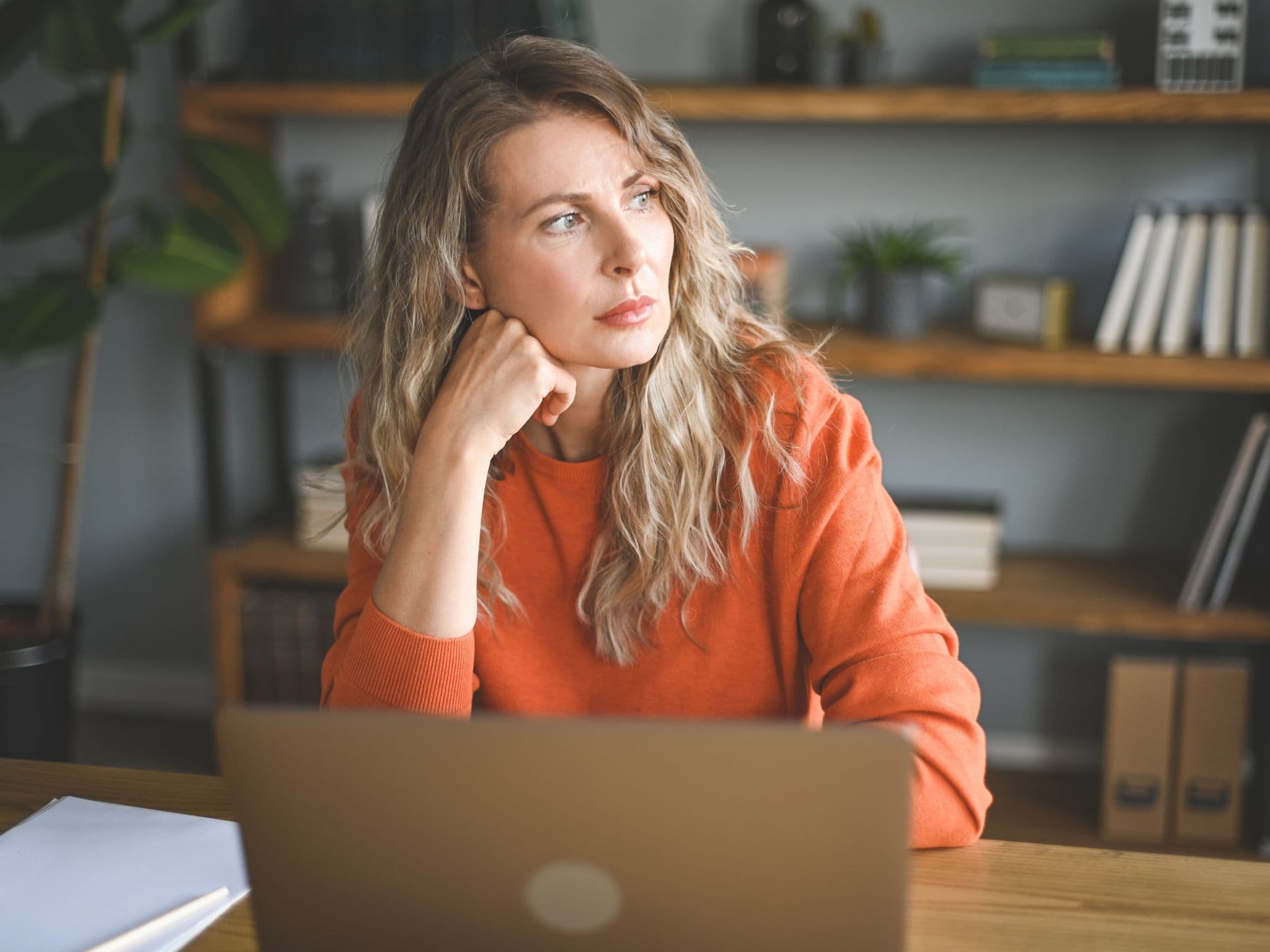 Wechseljahre am Arbeitsplatz: Eine Frau sitzt vor ihrem Computer und versucht, sich zu konzentrieren