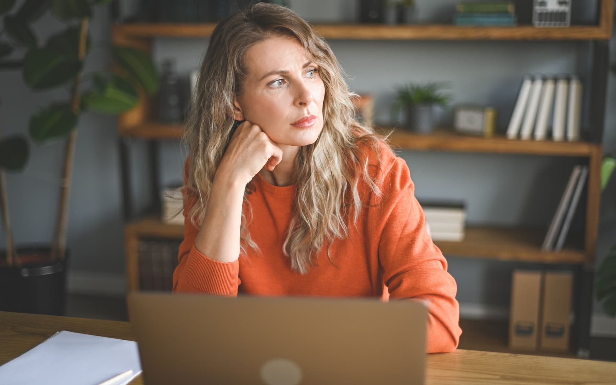 Wechseljahre am Arbeitsplatz: Eine Frau sitzt vor ihrem Computer und versucht, sich zu konzentrieren