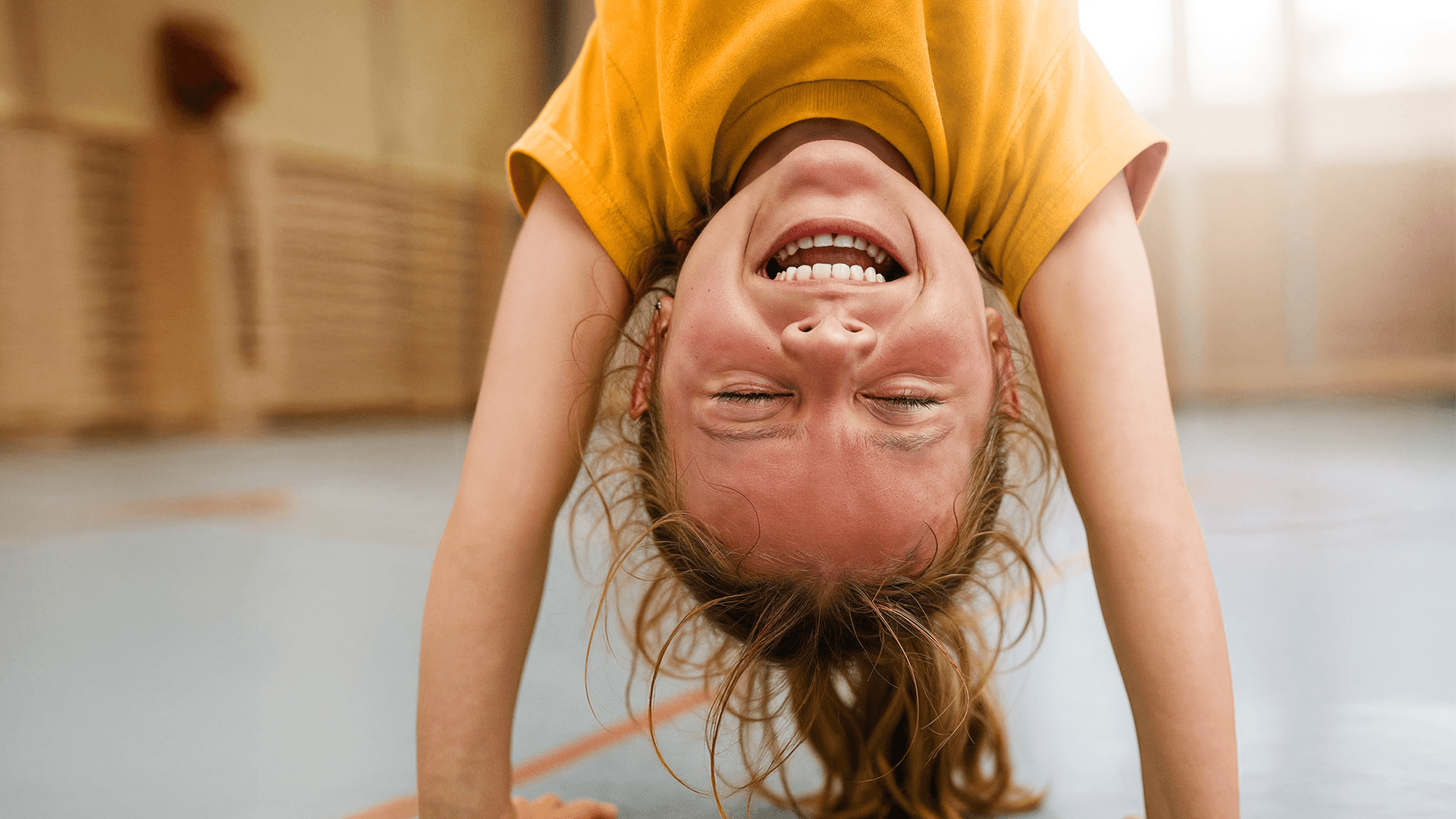 Ein kleines Kind macht einen Handstand und lacht im Close-up