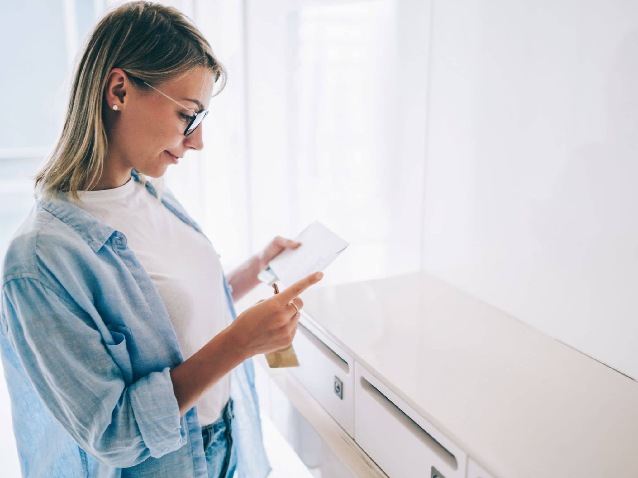 Eine Frau hat gerade den Freischaltbrief für die DAK App aus ihrem Briefkasten geholt.