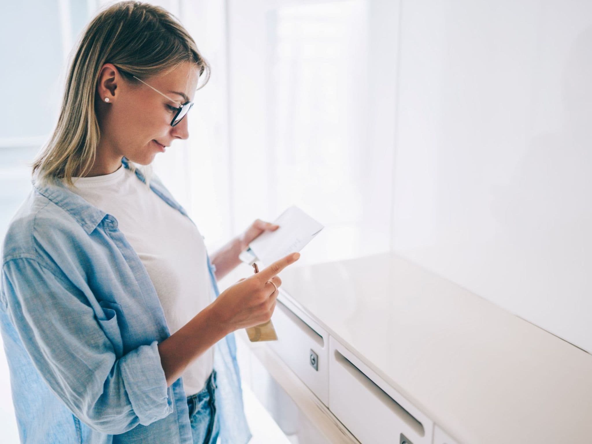 Eine Frau hat gerade den Freischaltbrief für die DAK App aus ihrem Briefkasten geholt.
