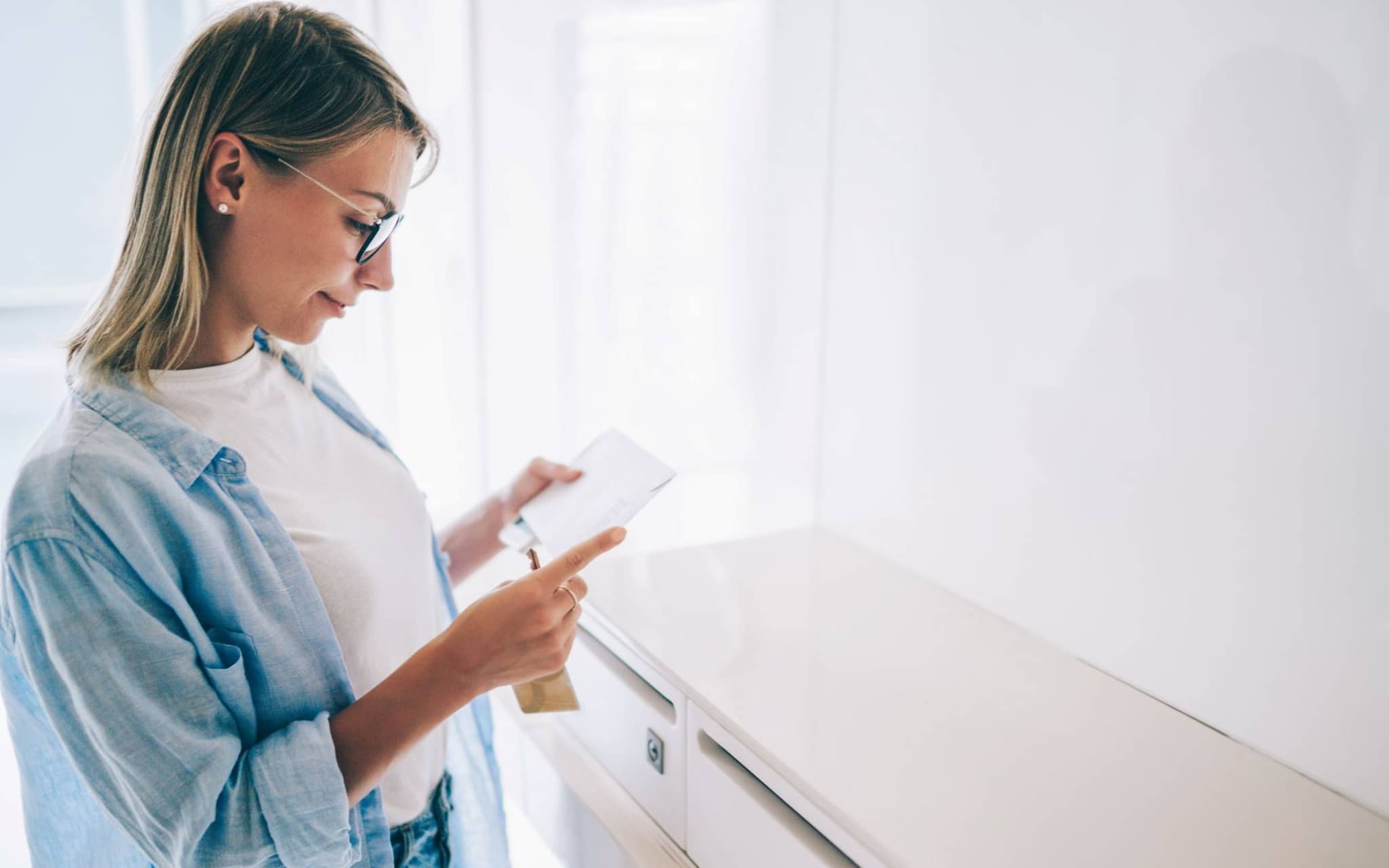 Eine Frau hat gerade den Freischaltbrief für die DAK App aus ihrem Briefkasten geholt.