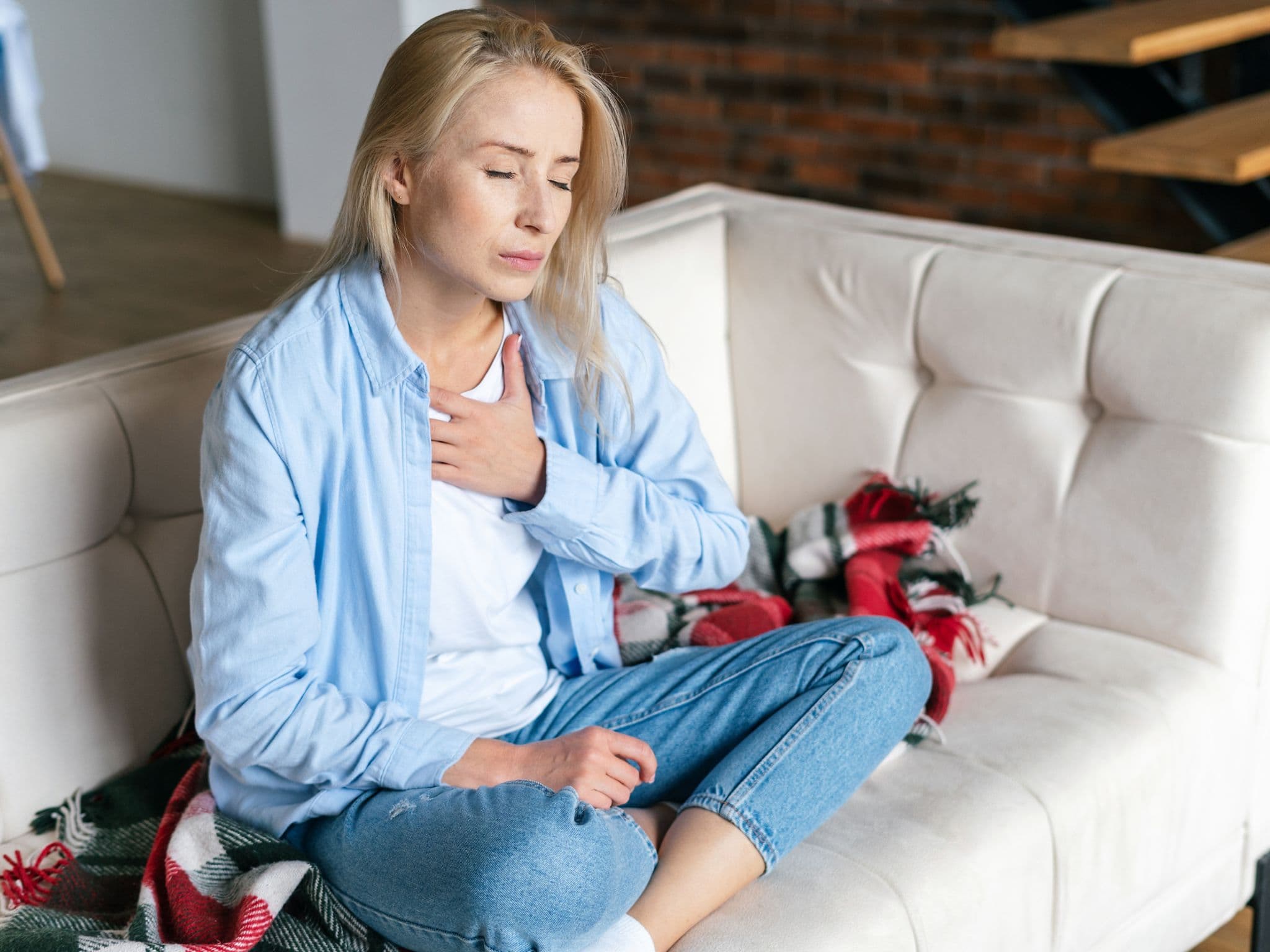 Broken-Heart-Syndrom: Eine Frau hält sich die Hände vor die Brust.
