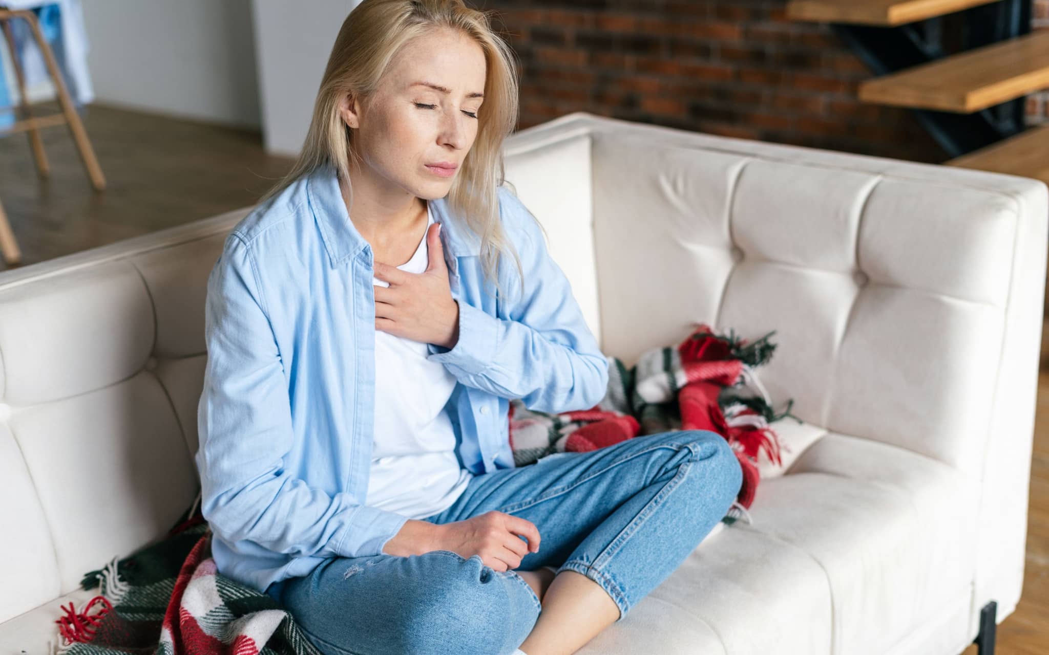 Broken-Heart-Syndrom: Eine Frau hält sich die Hände vor die Brust.