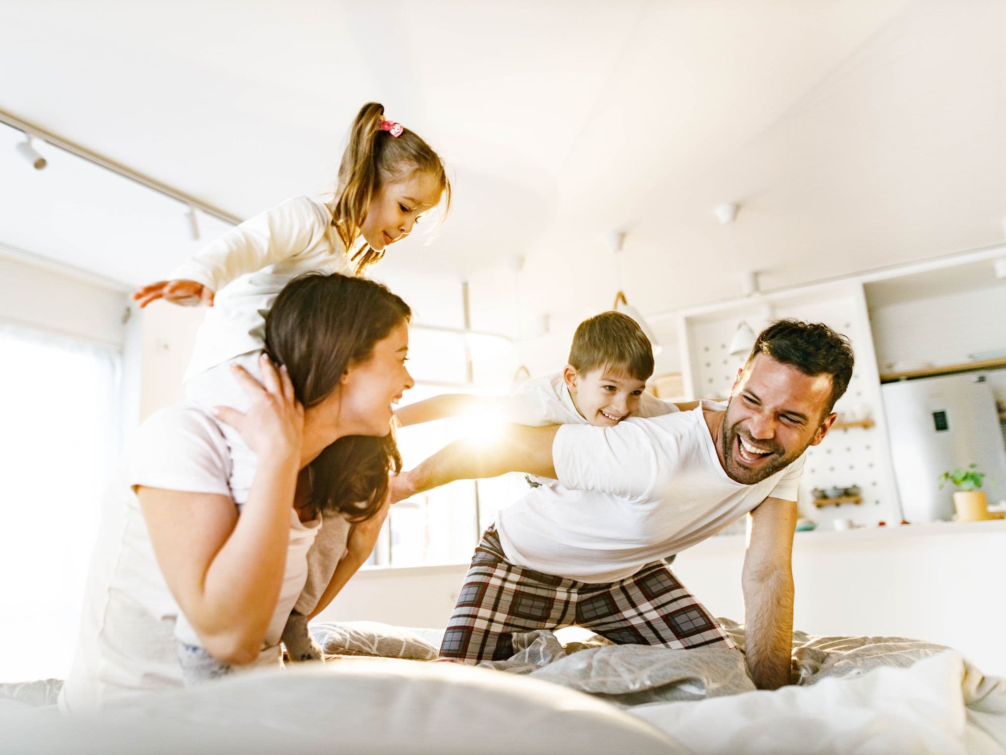 Unbeschwert mit der Familienversicherung. Eine Familie tobt herum.