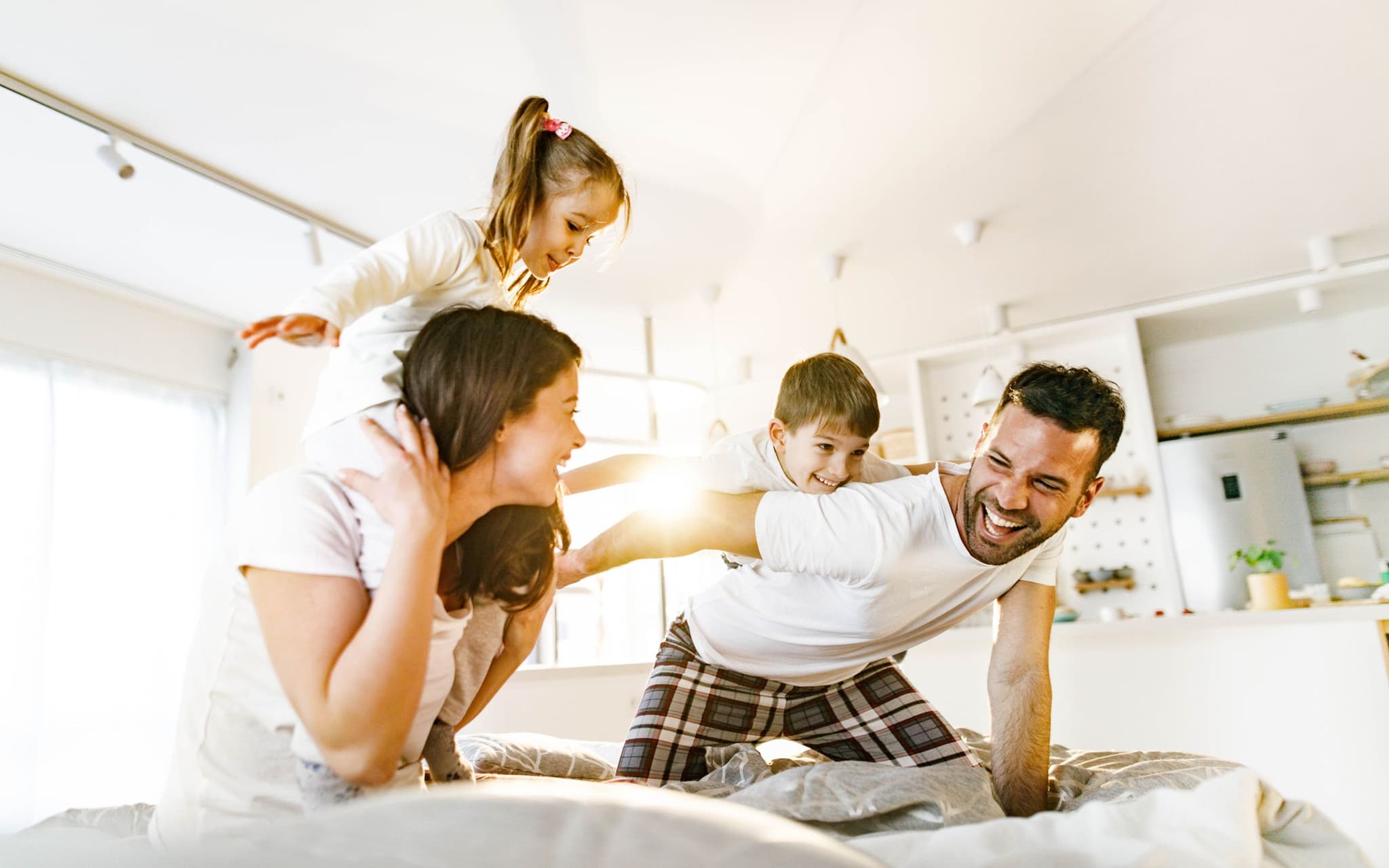 Unbeschwert mit der Familienversicherung. Eine Familie tobt herum.