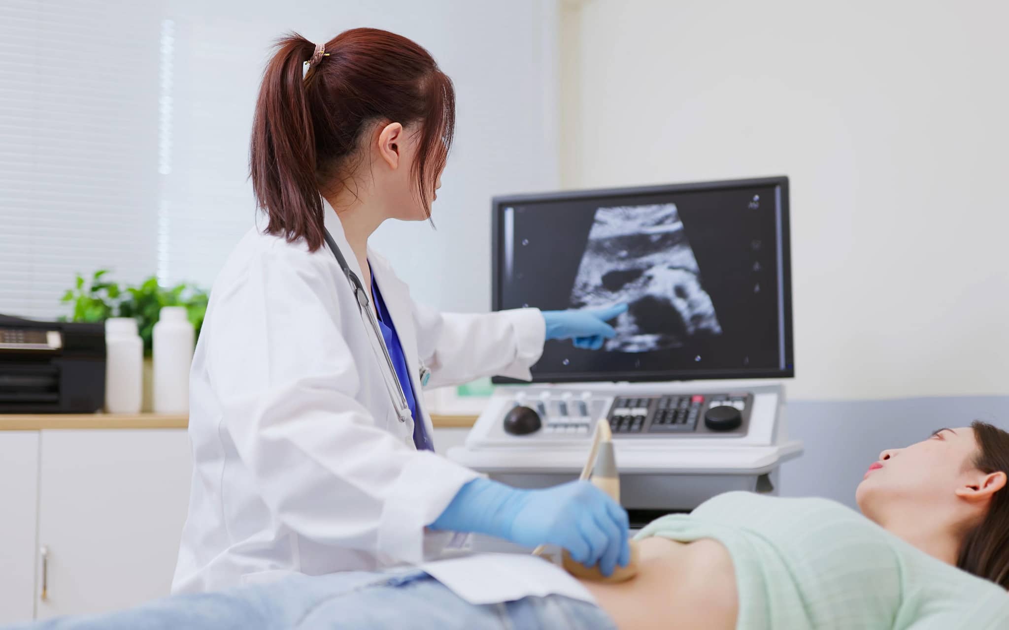 Myome: Eine Gynäkologin untersucht eine Frau mit einem Ultraschallgerät und zeigt ein Myom in der Gebärmutter