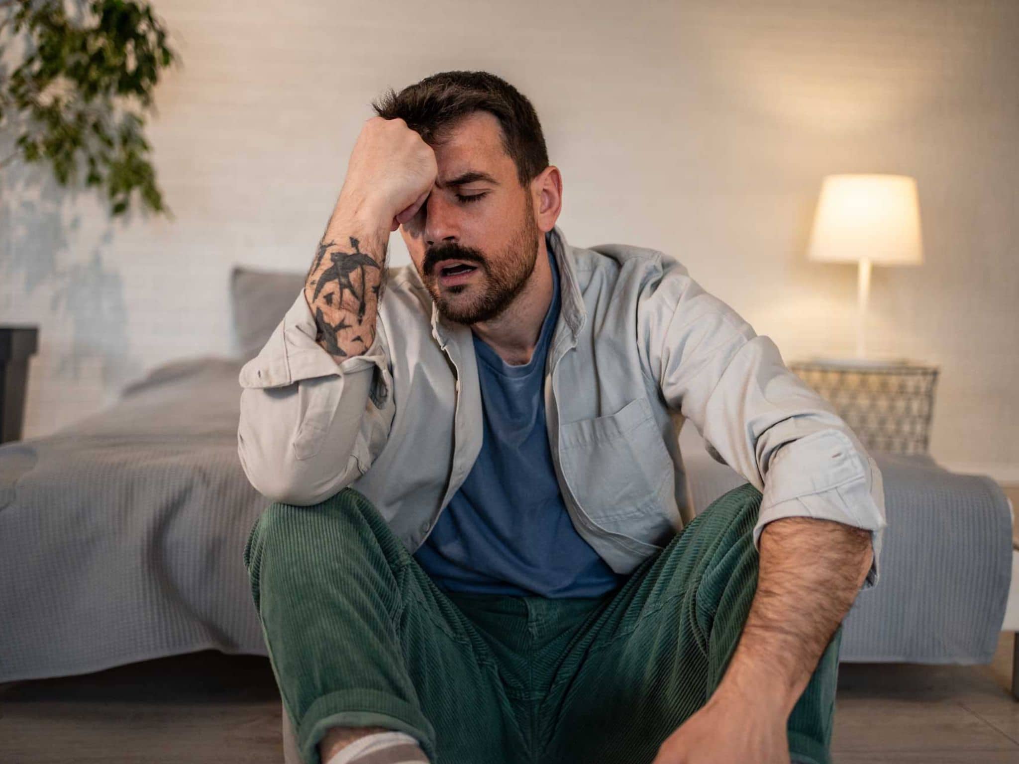 Mann sitzt erschöpft auf dem Boden