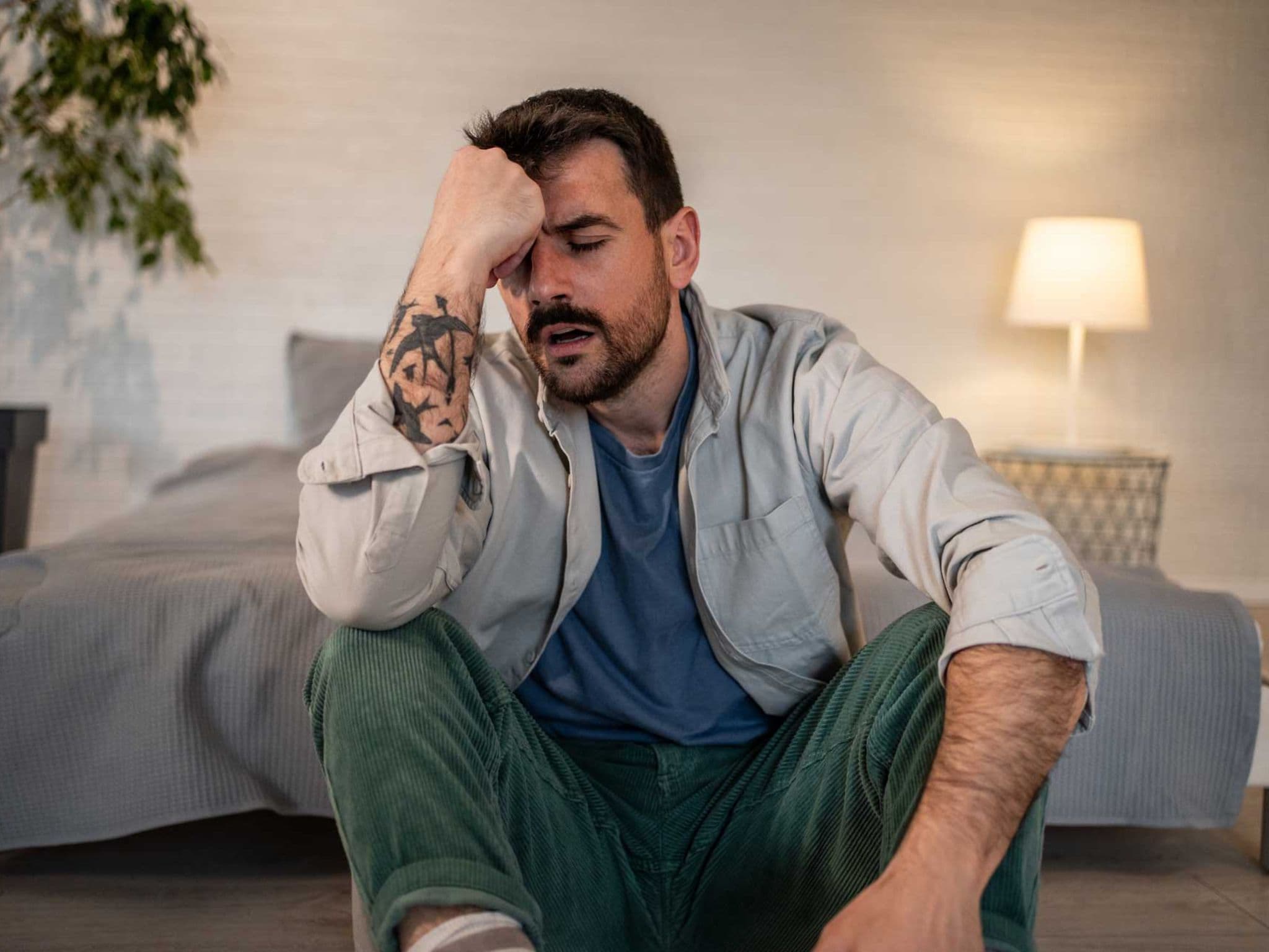 Mann sitzt erschöpft auf dem Boden