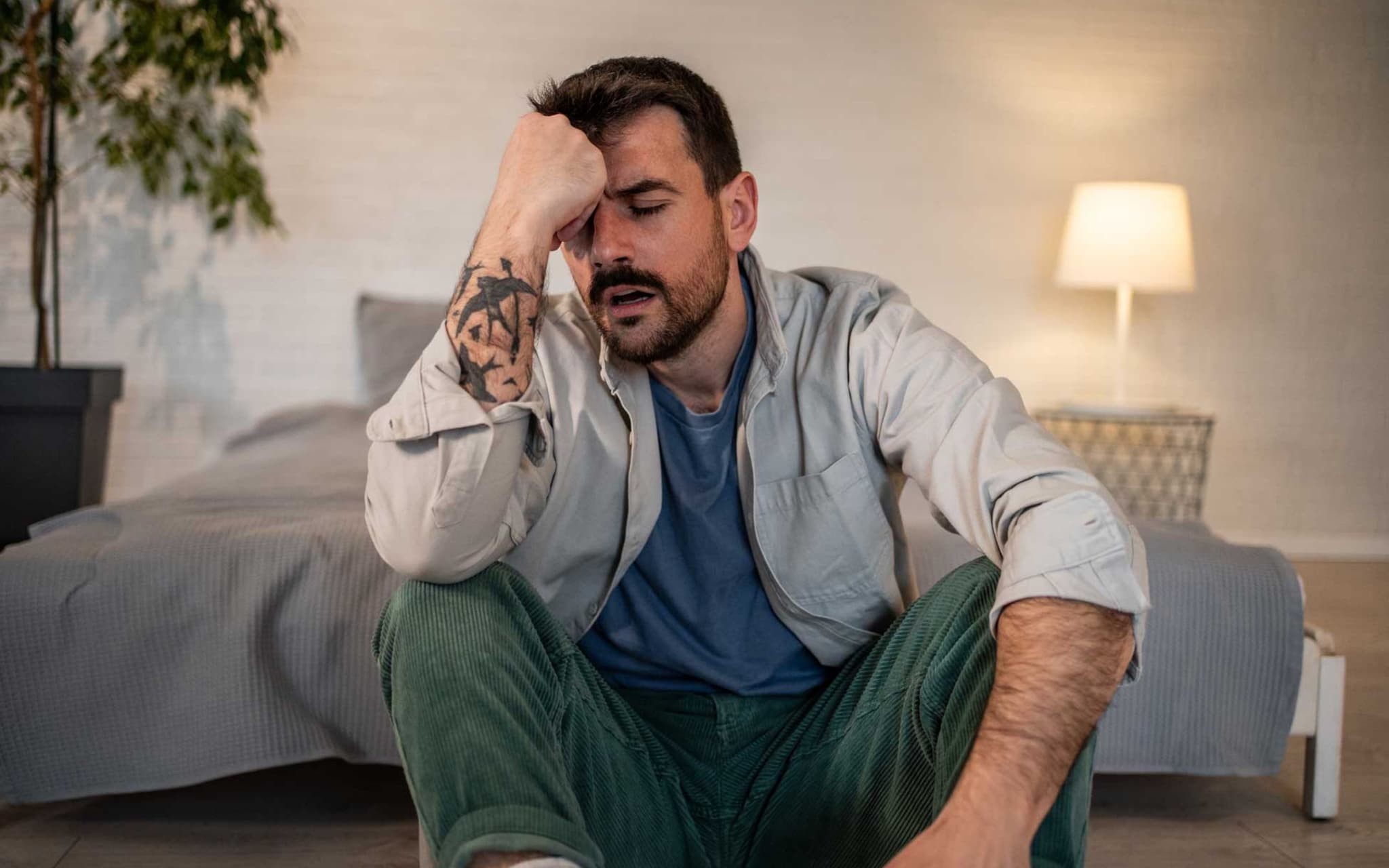 Mann sitzt erschöpft auf dem Boden