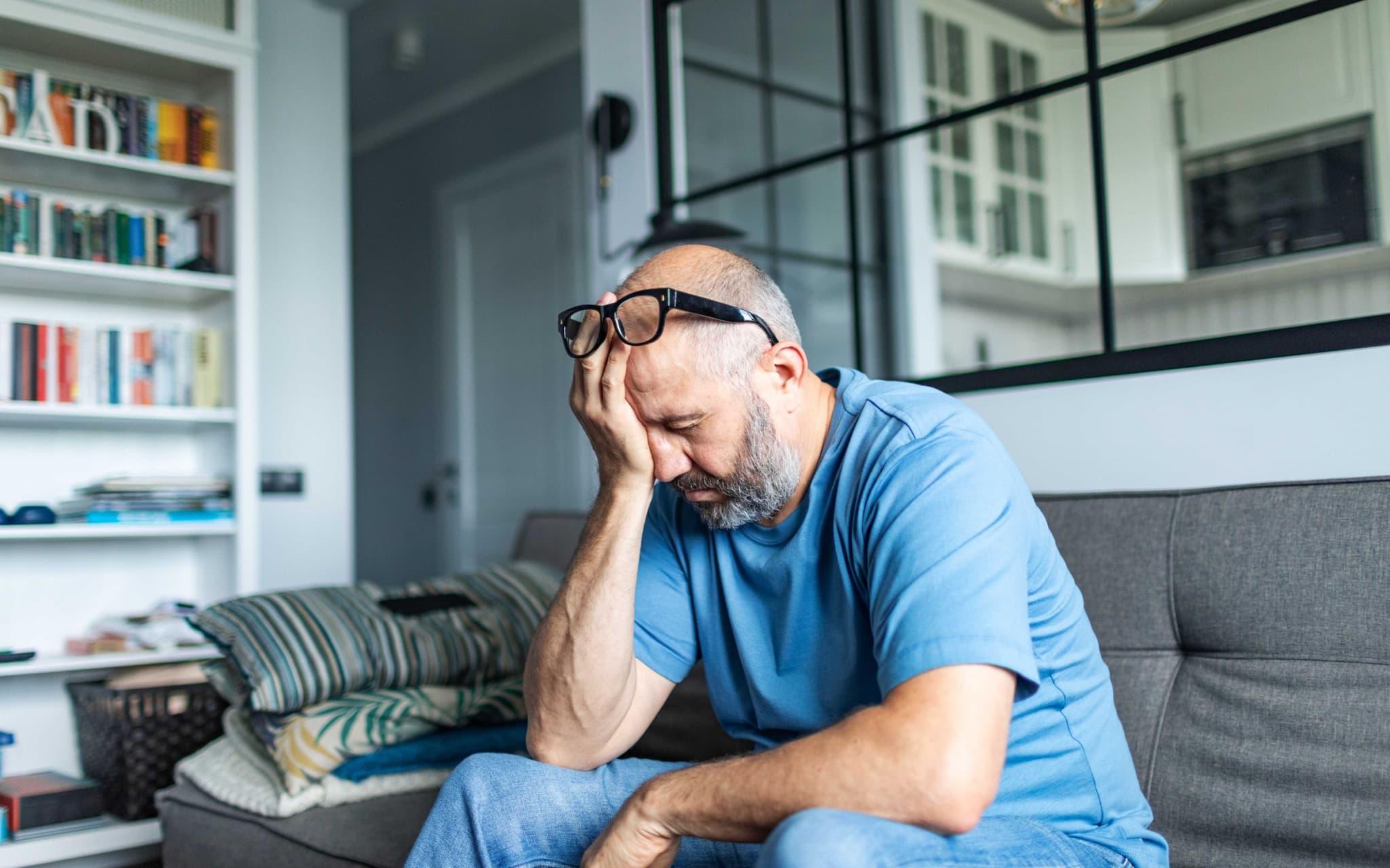 Altersdepressionen: Ein älterer Mann sitzt auf einem Sofa und denkt nach
