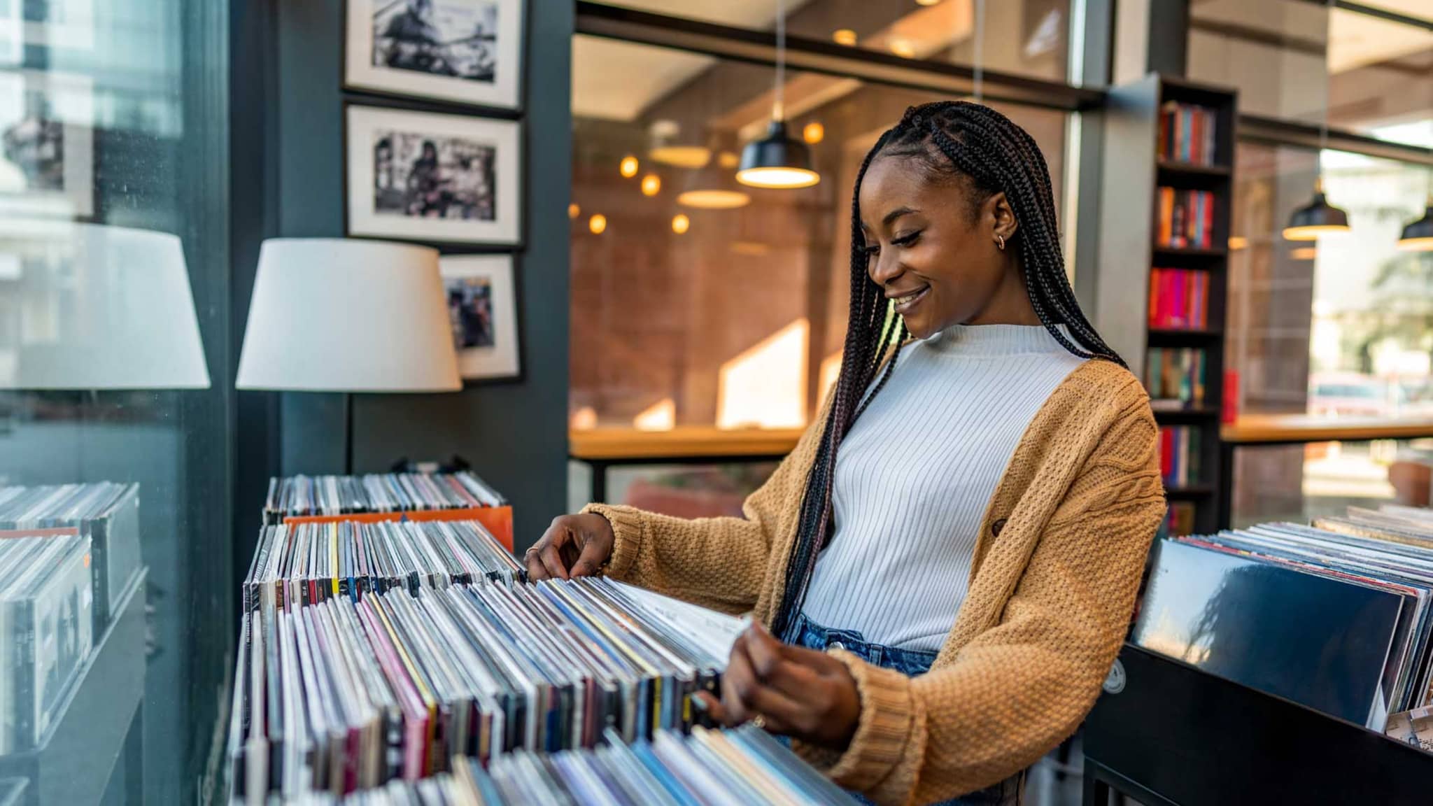 Junge Frau verschafft sich in einem Plattenladen einen Überblick