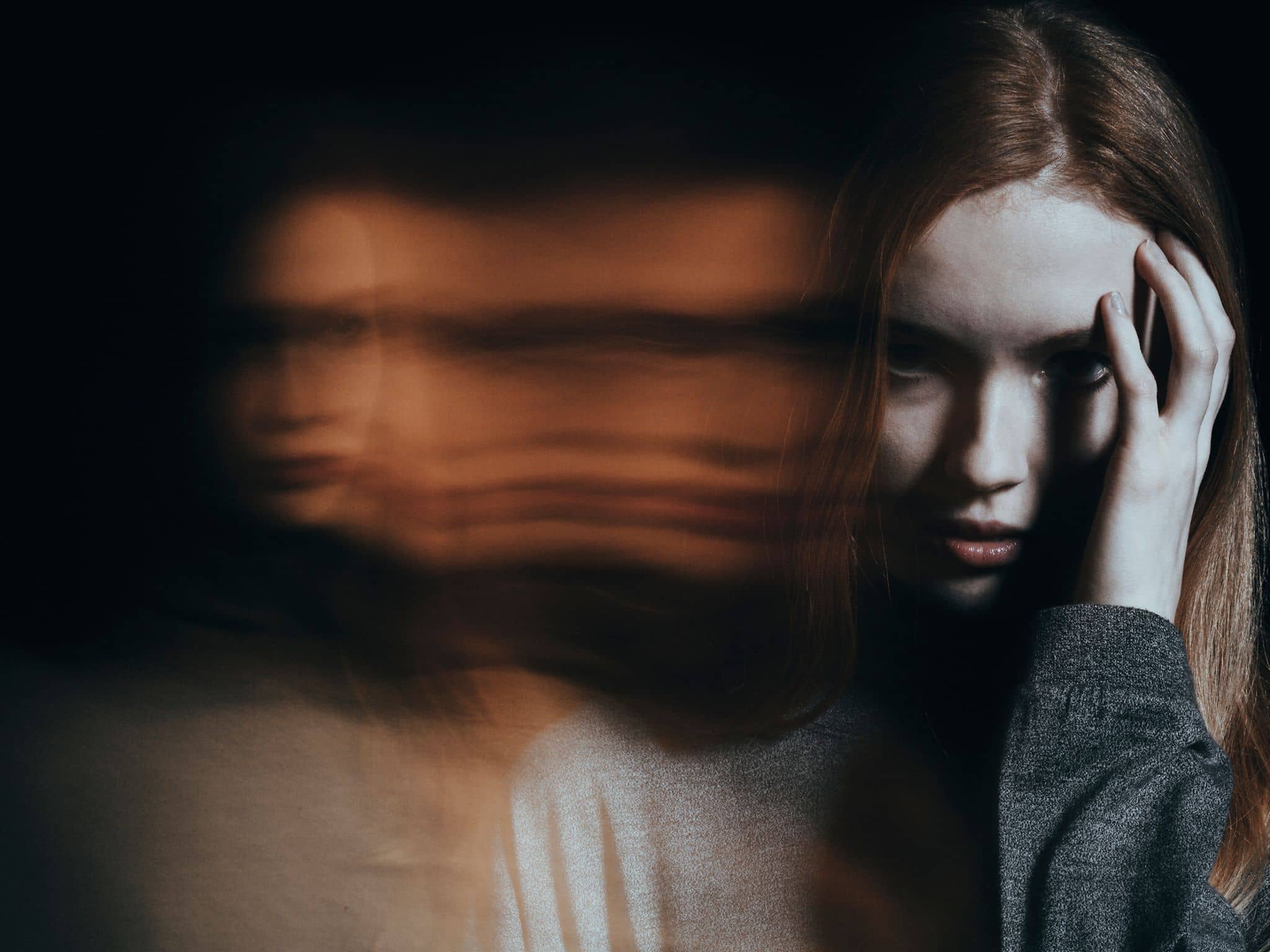 Adipositas: Ein kleiner Junge liegt auf dem Sofa und isst einen Hamburger und Pommes Frites.