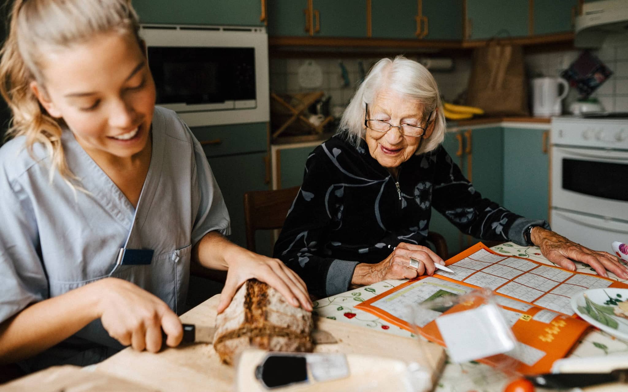 Azubi in der Pflege bei einer älteren Frau zuhause.