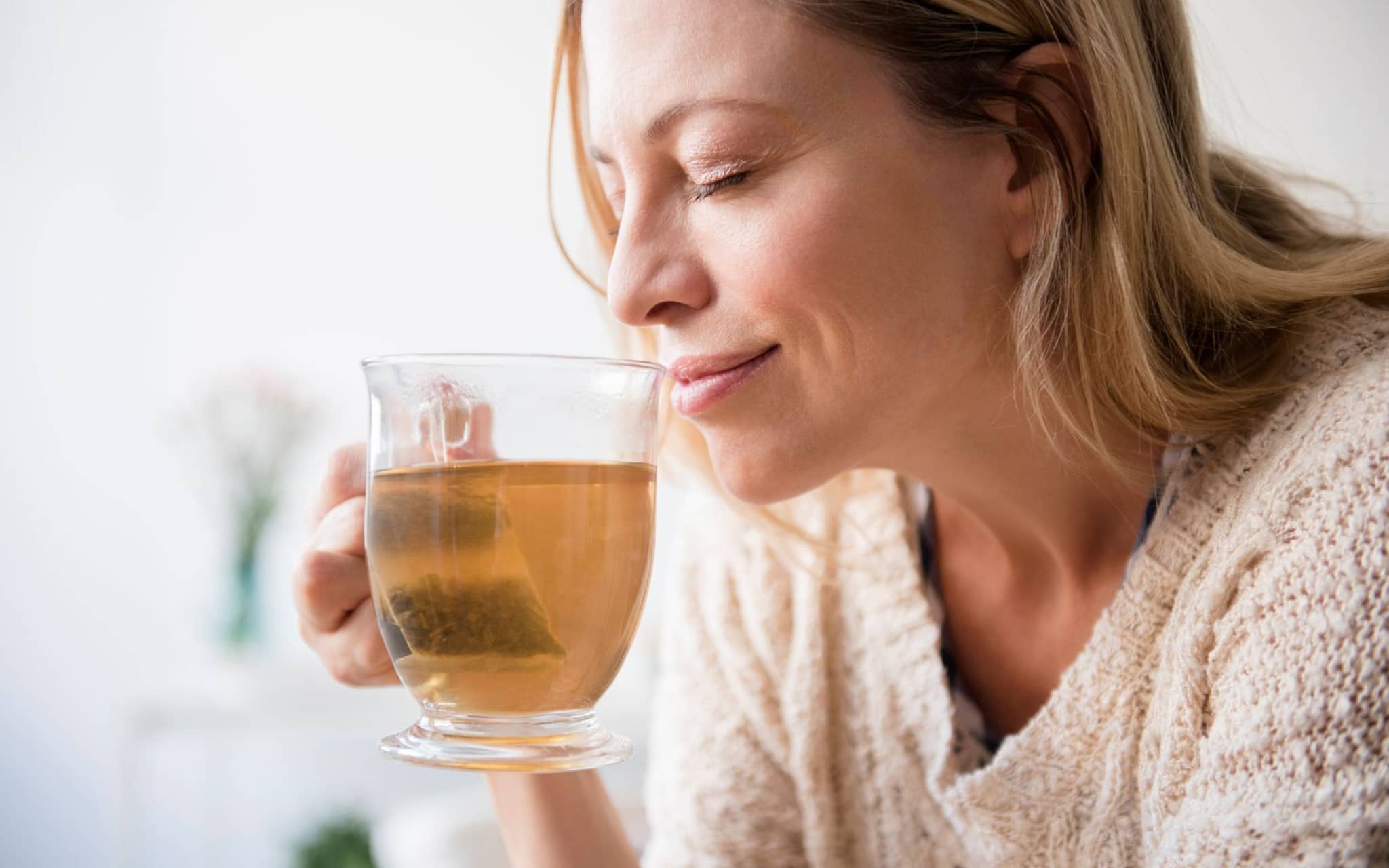 Eine Frau trinkt einen Tee - ein bewährtes Hausmittel gegen Schnupfen