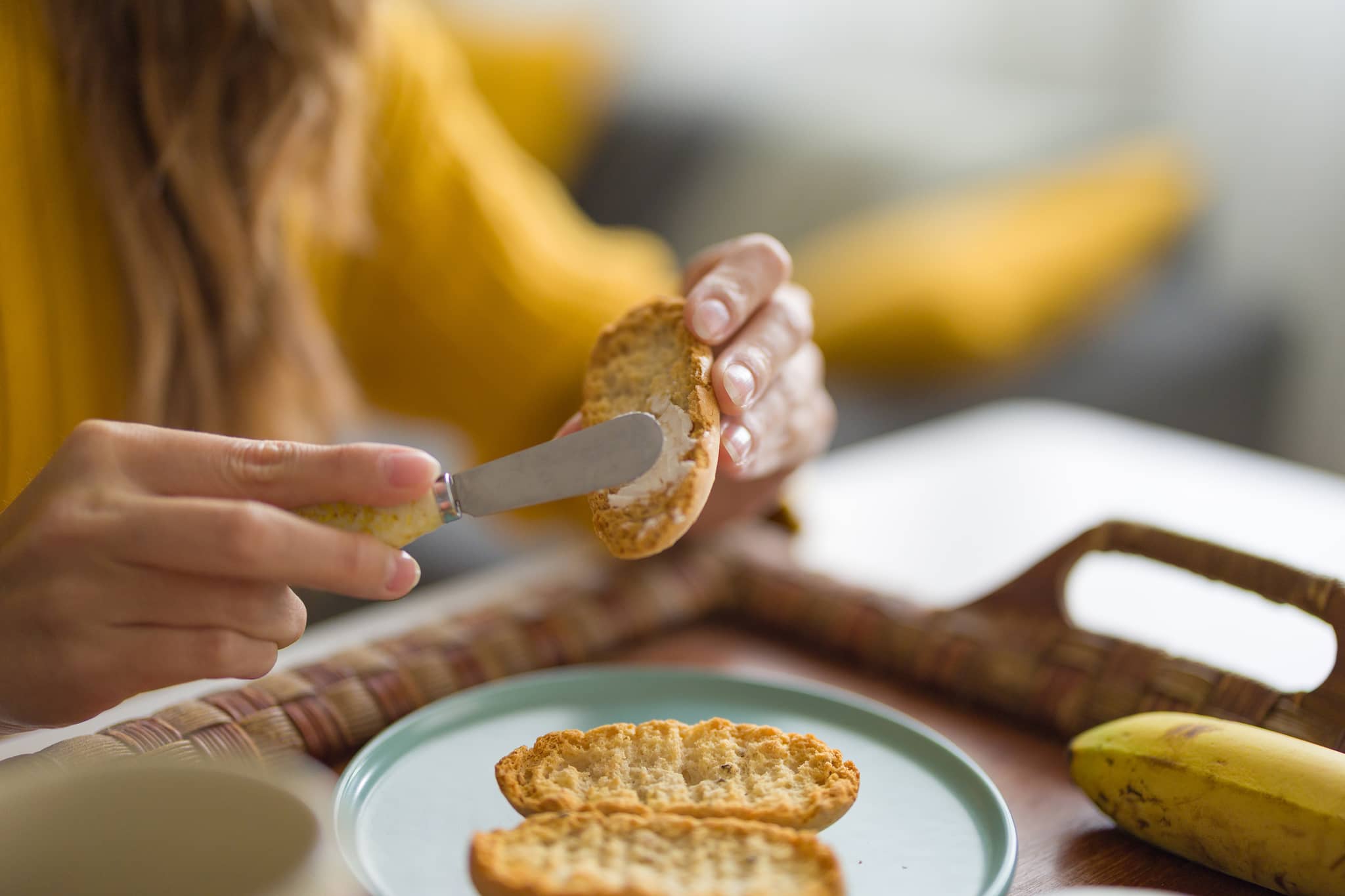 Frau bereitet Essen bei Übelkeit zu - Zwieback und Banane