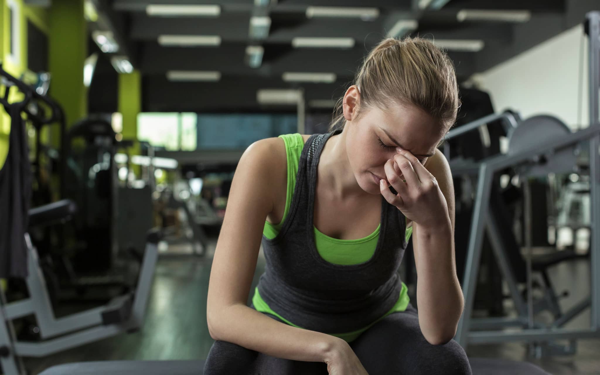 Sportlerin greift sich erschöpft an den Nasenrücken