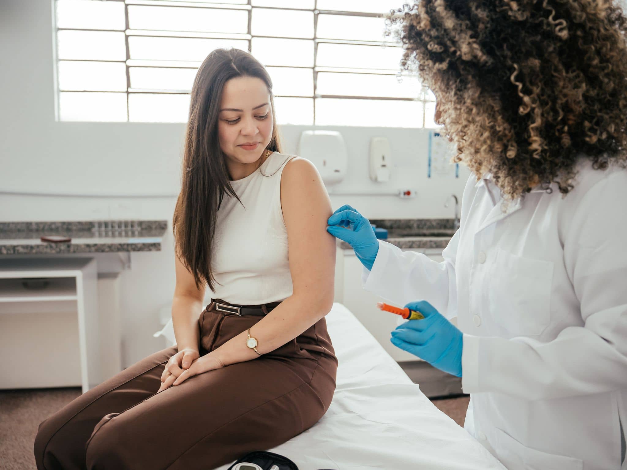 Dreimonatsspritze: Eine Gynäkologin spritzt einer Frau eine Verhütungsspritze