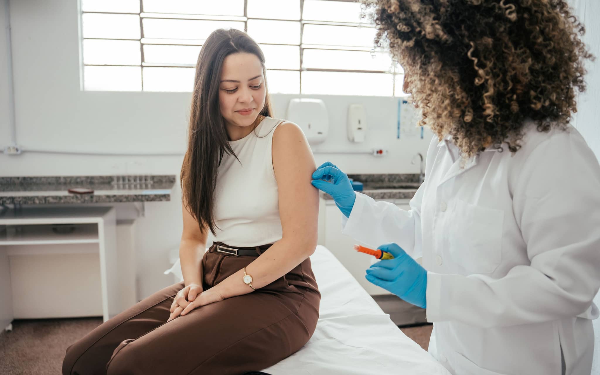 Dreimonatsspritze: Eine Gynäkologin spritzt einer Frau eine Verhütungsspritze