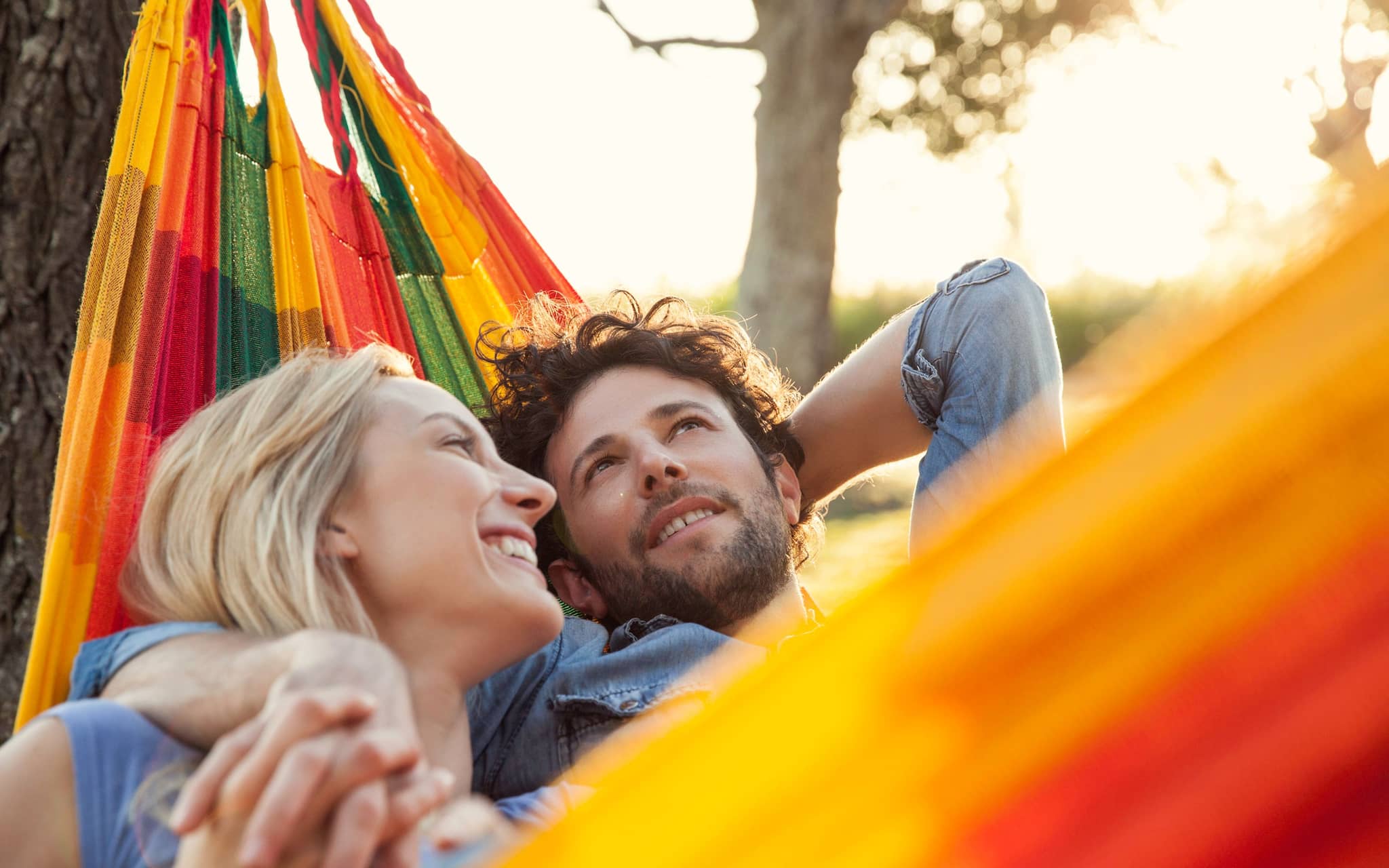 Rebound-Beziehung: Ein verliebtes Paar liegt schmusend in einer Hängematte