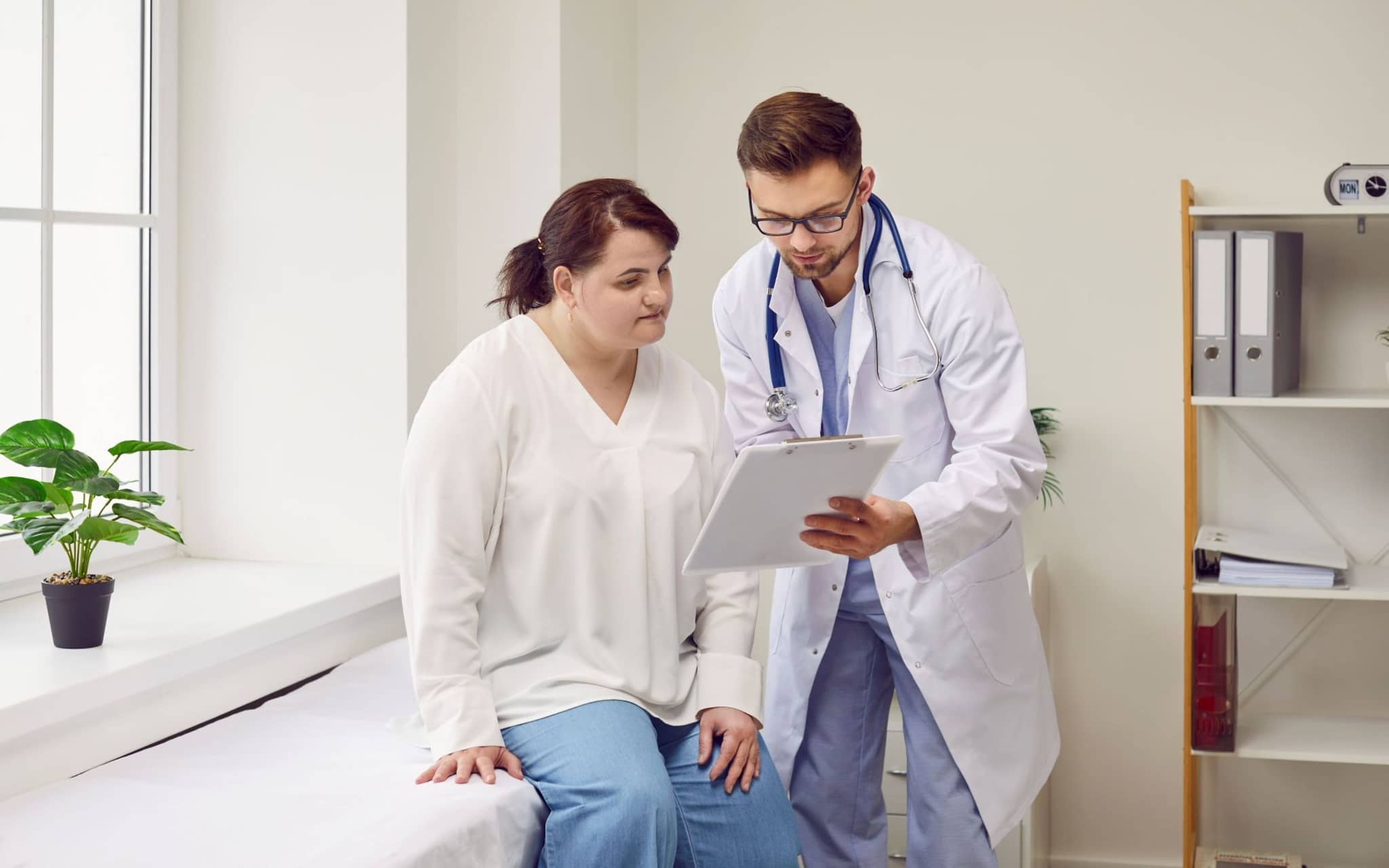 Ein Arzt spricht im Rahmen der Nachsorge nach einer bariatrischen OP mit einer Patientin.