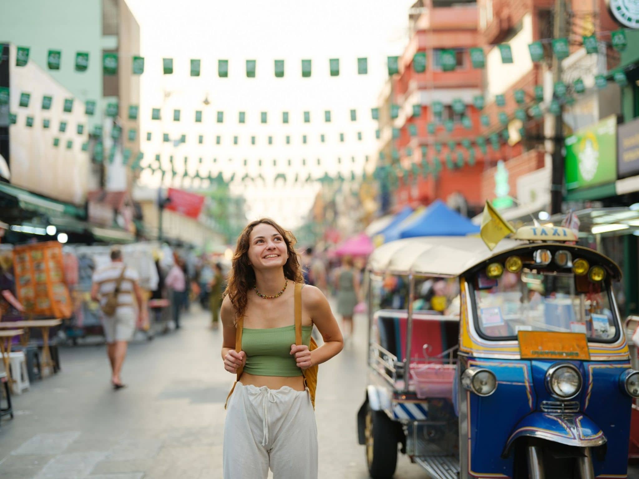 Eine junge Frau spaziert gut geschützt dank Hepatitis-A-Impfung durch Bangkoks Straßen.