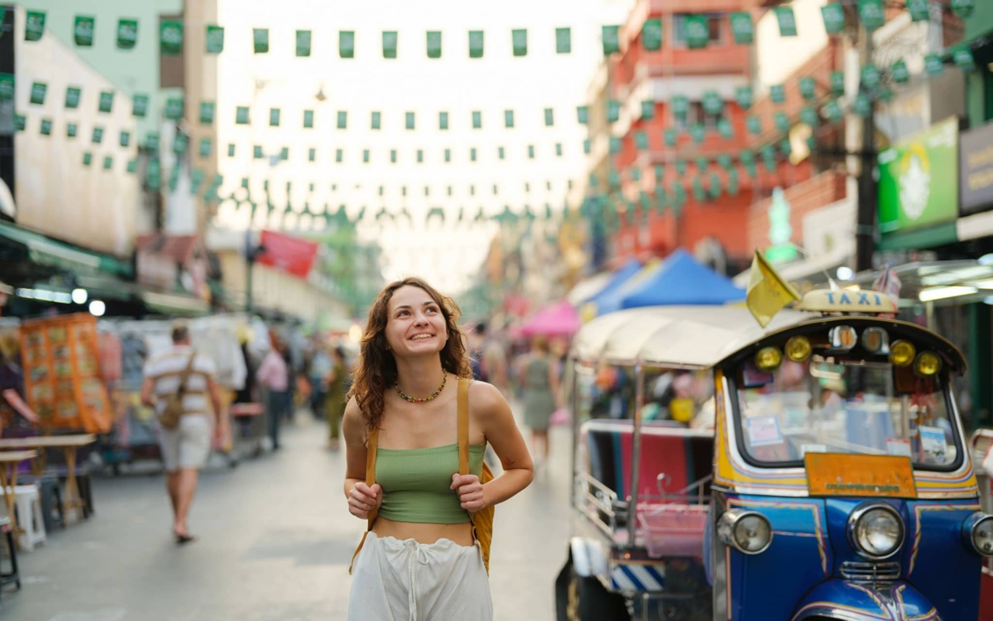 Eine junge Frau spaziert gut geschützt dank Hepatitis-A-Impfung durch Bangkoks Straßen.