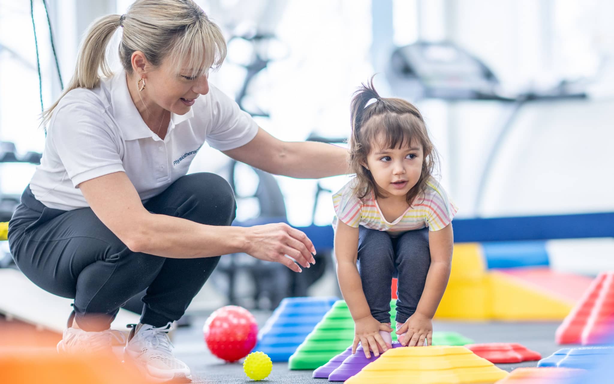 Kleines Mädchen balanciert im Rahmen ihrer Ergotherapie
