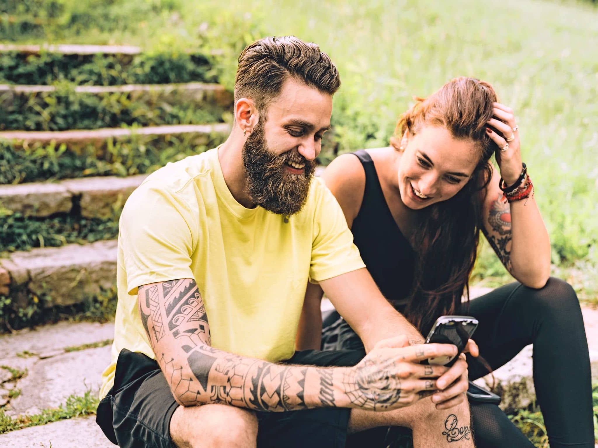 Eine Frau und ein Mann schauen nach dem Sport auf ein Handy.