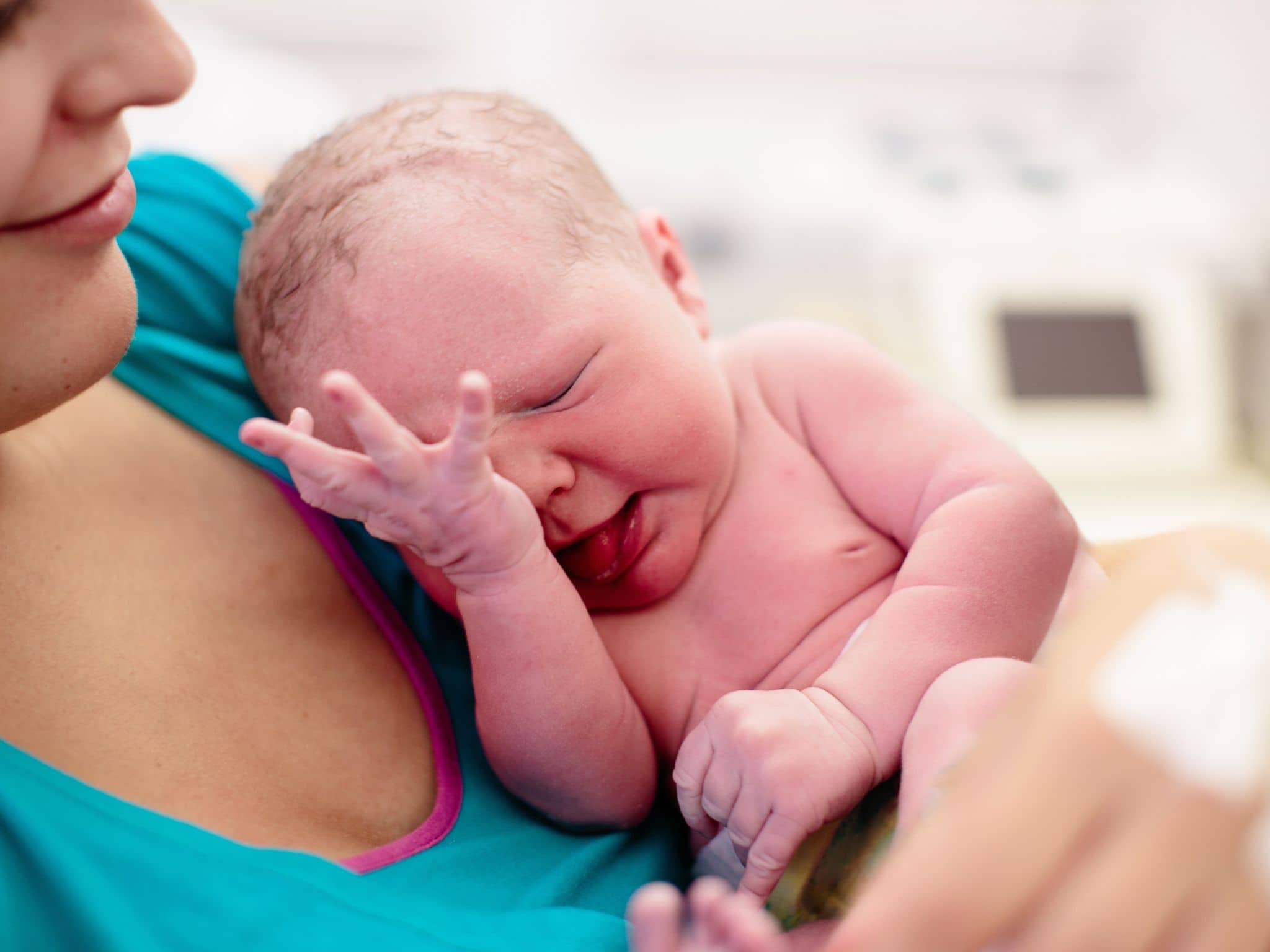 Eine Frau hält ihr neugeborenes Baby auf dem Arm.