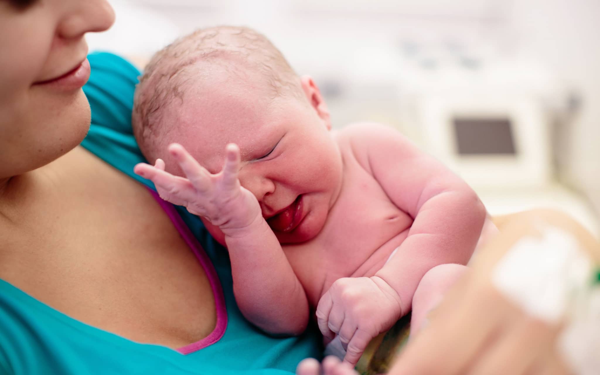 Eine Frau hält ihr neugeborenes Baby auf dem Arm.