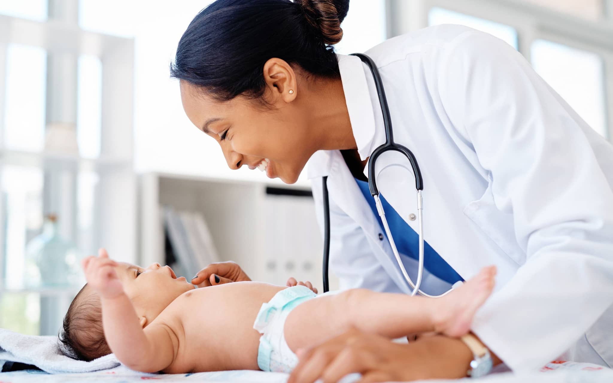 Ein Säugling wird von einer Ärztin untersucht.