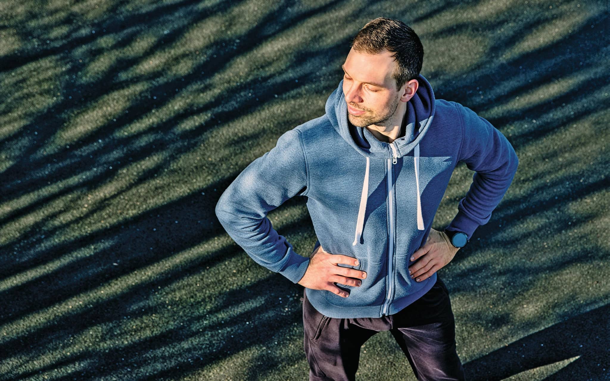 Mann steht mit geschlossenen Augen auf Rasen.