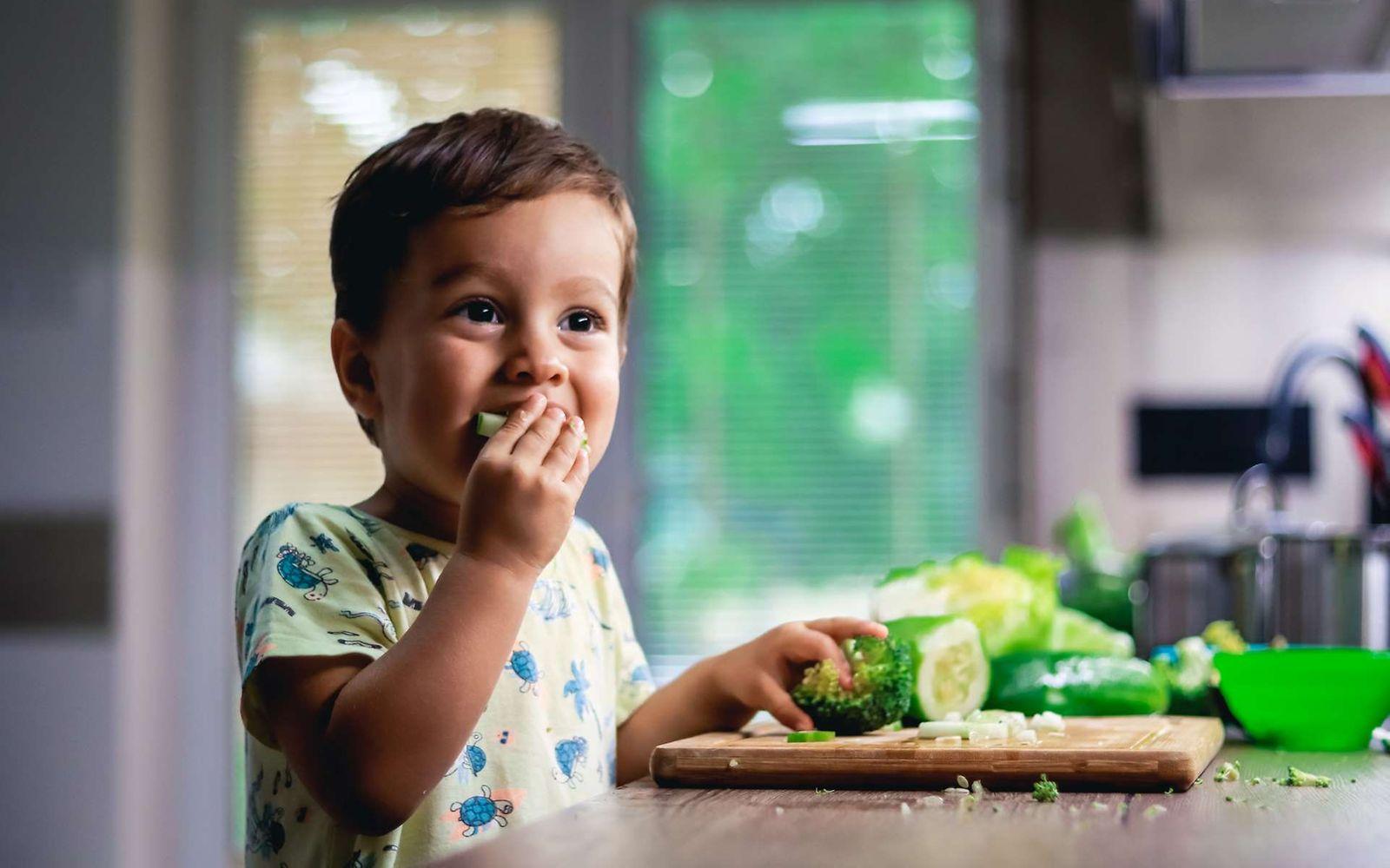 Rohes Gemüse: Kleines Kind isst Brokkoli und Zucchini