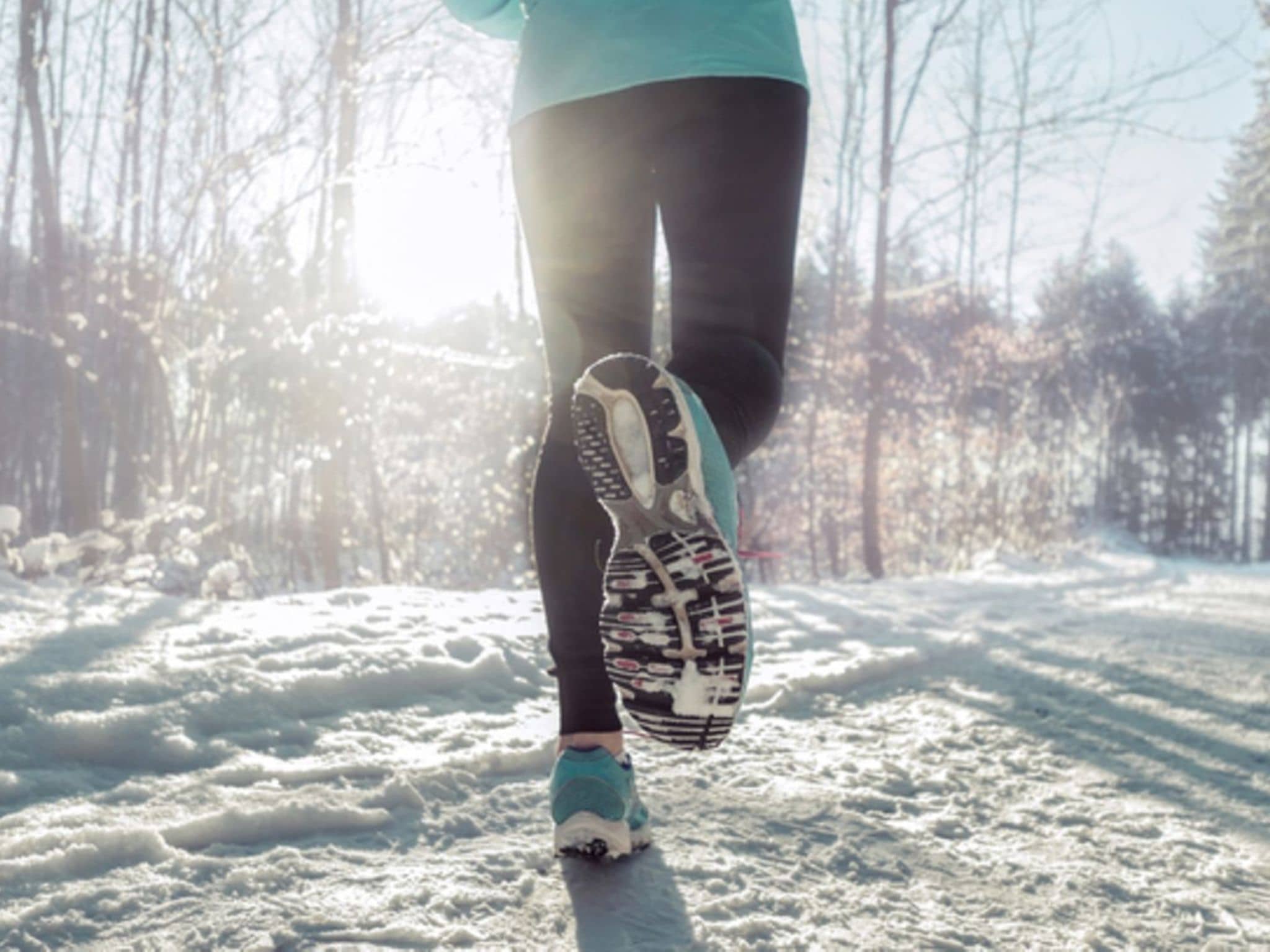 Laufen im Winter: Eine Person läuft durch einen verschneiten Wald.