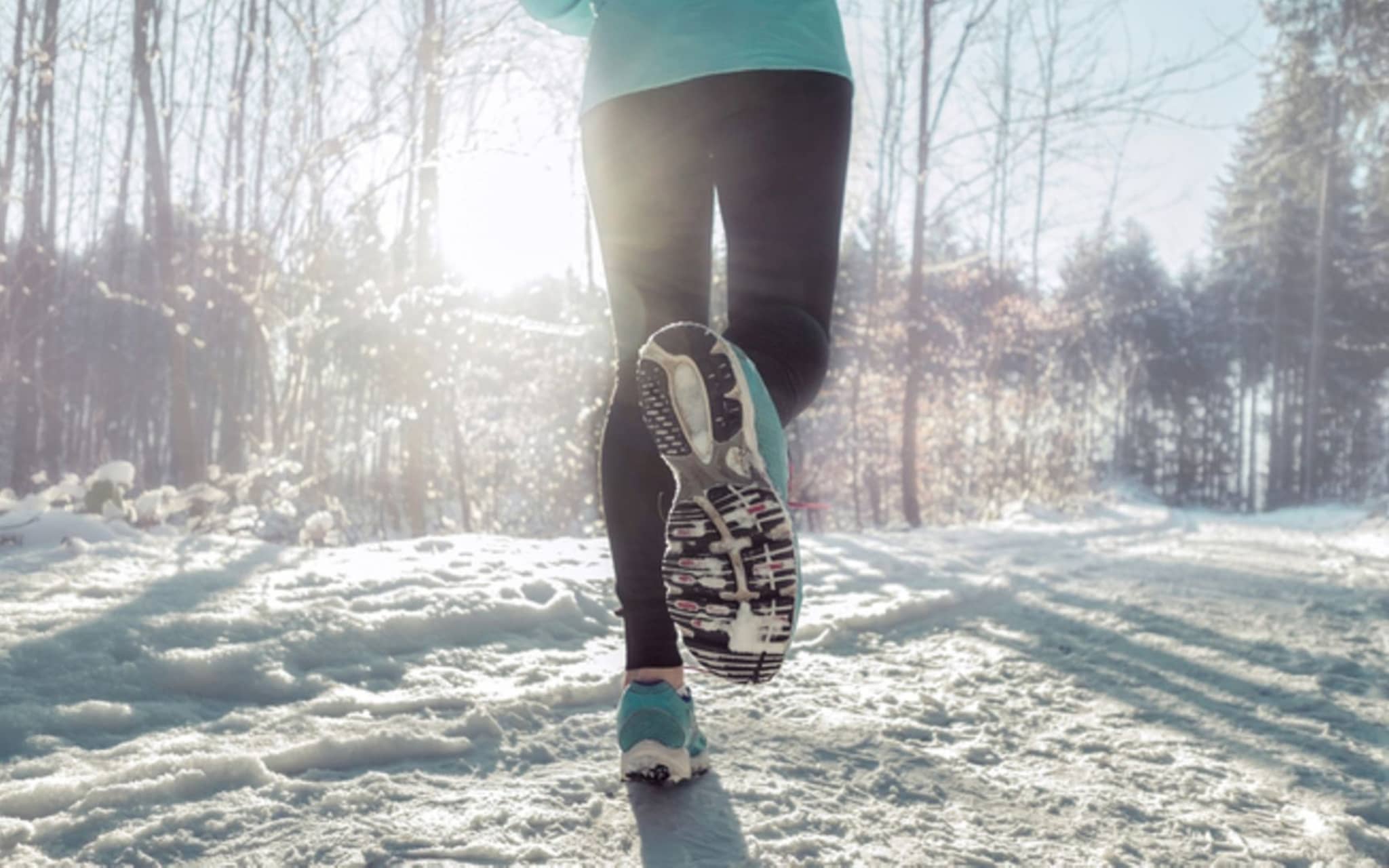 Laufen im Winter: Eine Person läuft durch einen verschneiten Wald.