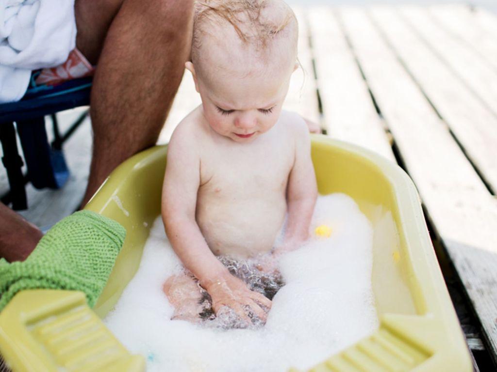 Körperpflege bei Kindern: Ein Baby sitzt in der Kinderwanne und badet.