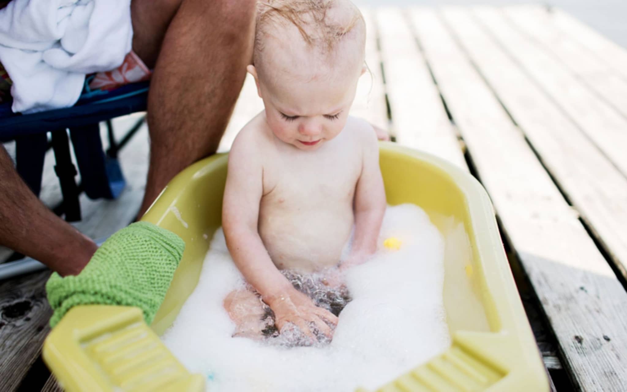 Körperpflege bei Kindern: Ein Baby sitzt in der Kinderwanne und badet.