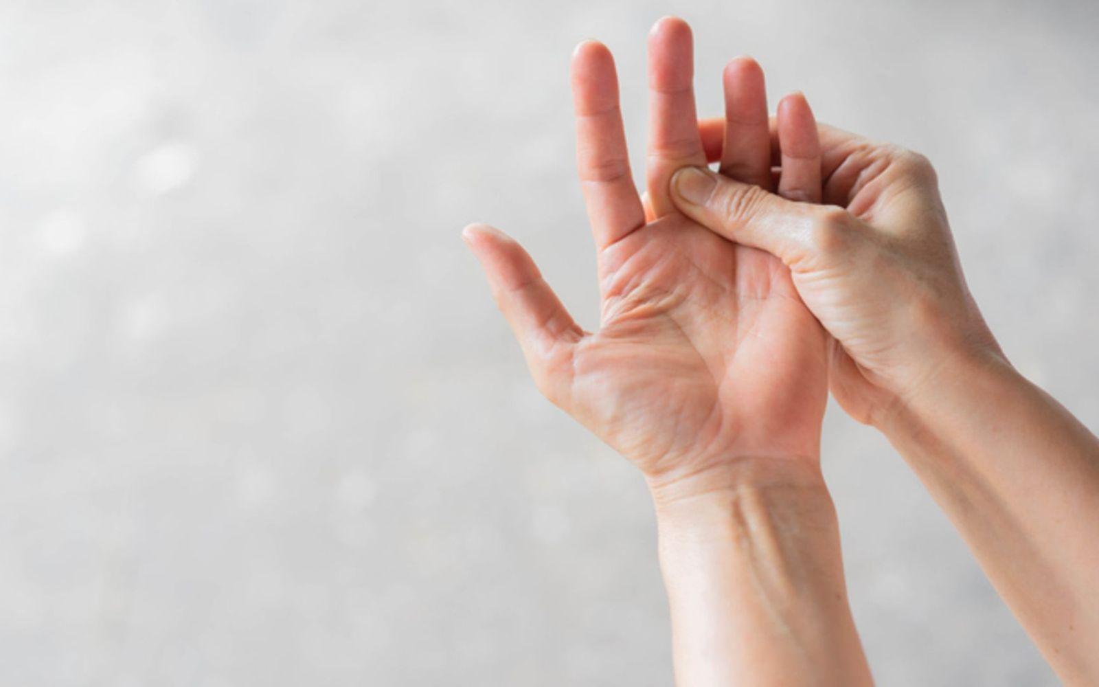 Fingerknacken: Frau umfasst ihren Mittelfinger der anderen Hand