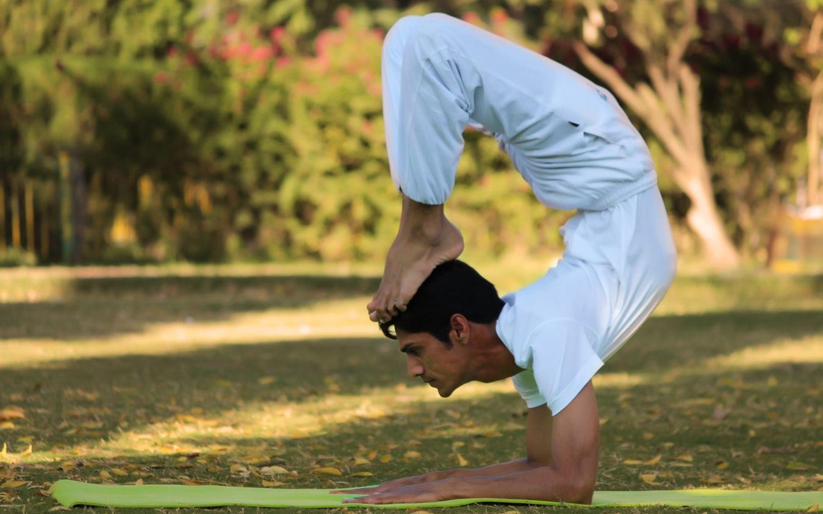 Yoga für Männer: Indian Yogi (Yogi Madhav) macht Yoga in einem Park.