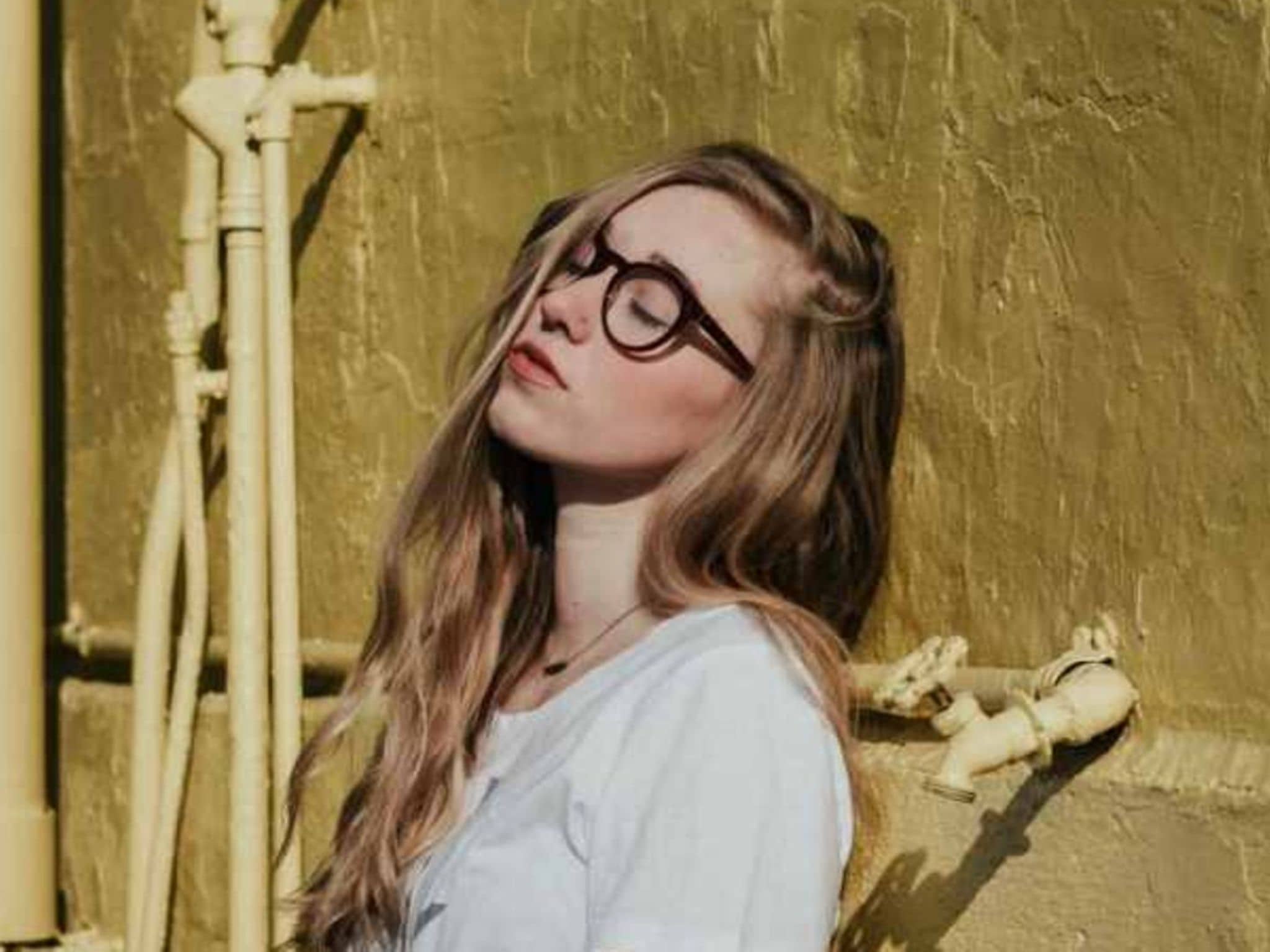 Alleine sein: Eine junge Frau mit Brille genießt das Alleinsein