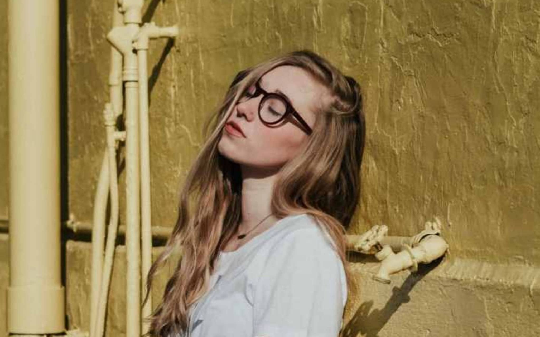 Alleine sein: Eine junge Frau mit Brille genießt das Alleinsein