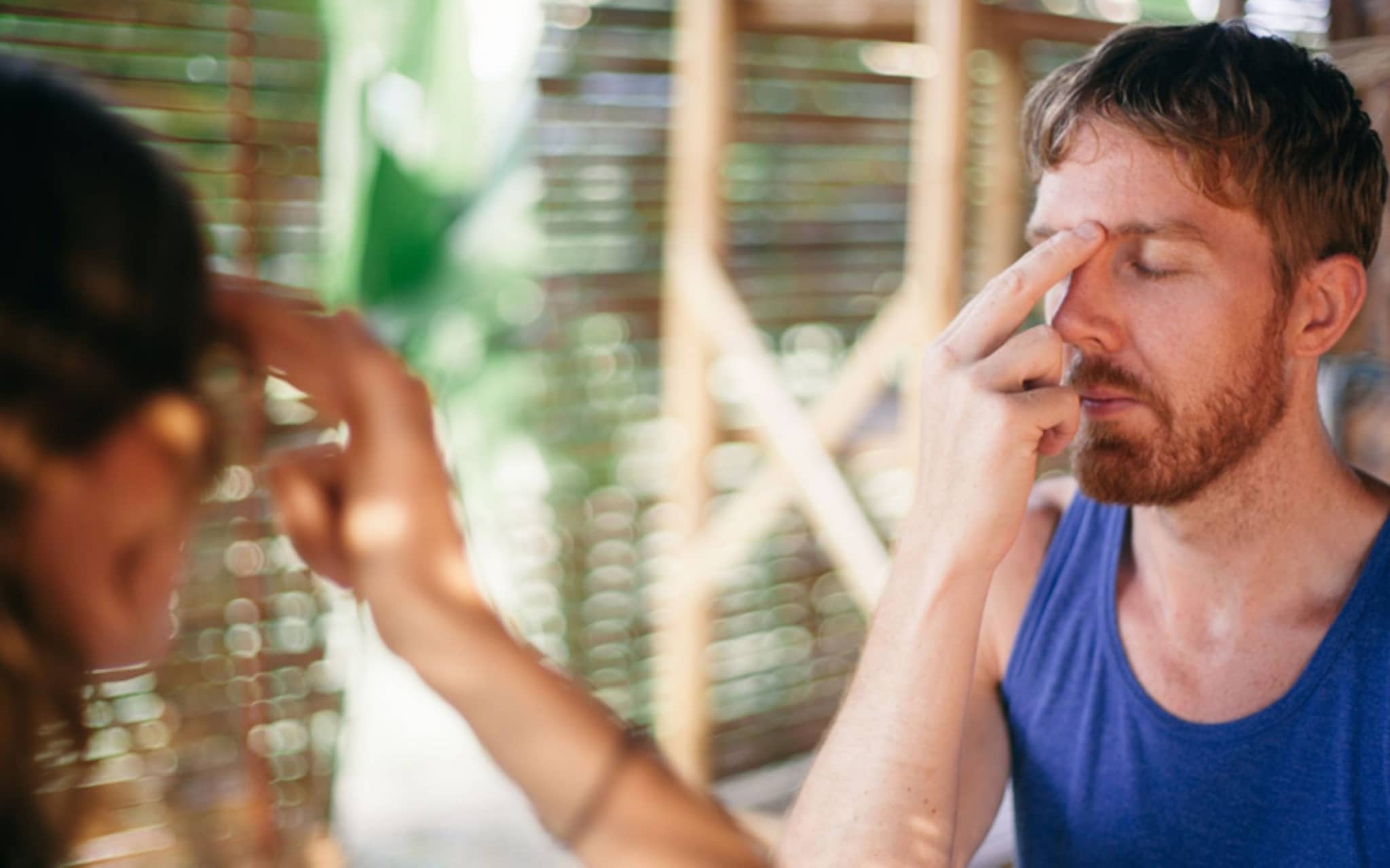 Mann wendet an der Stirn Akupressur an