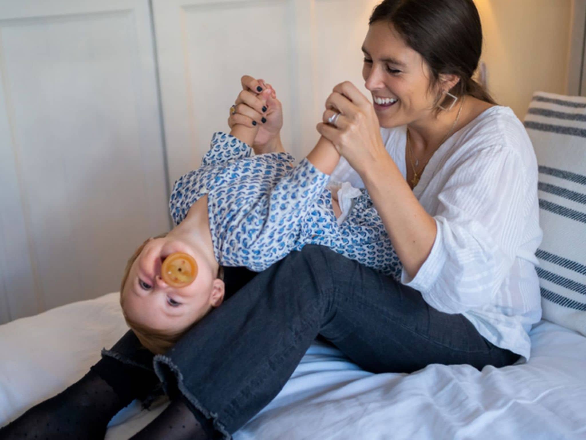 Babyspiele: Mutter und Baby turnen im Bett