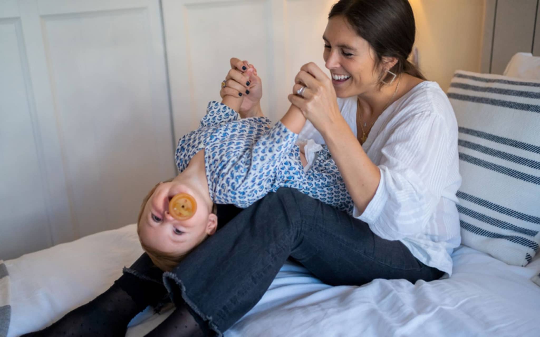 Babyspiele: Mutter und Baby turnen im Bett