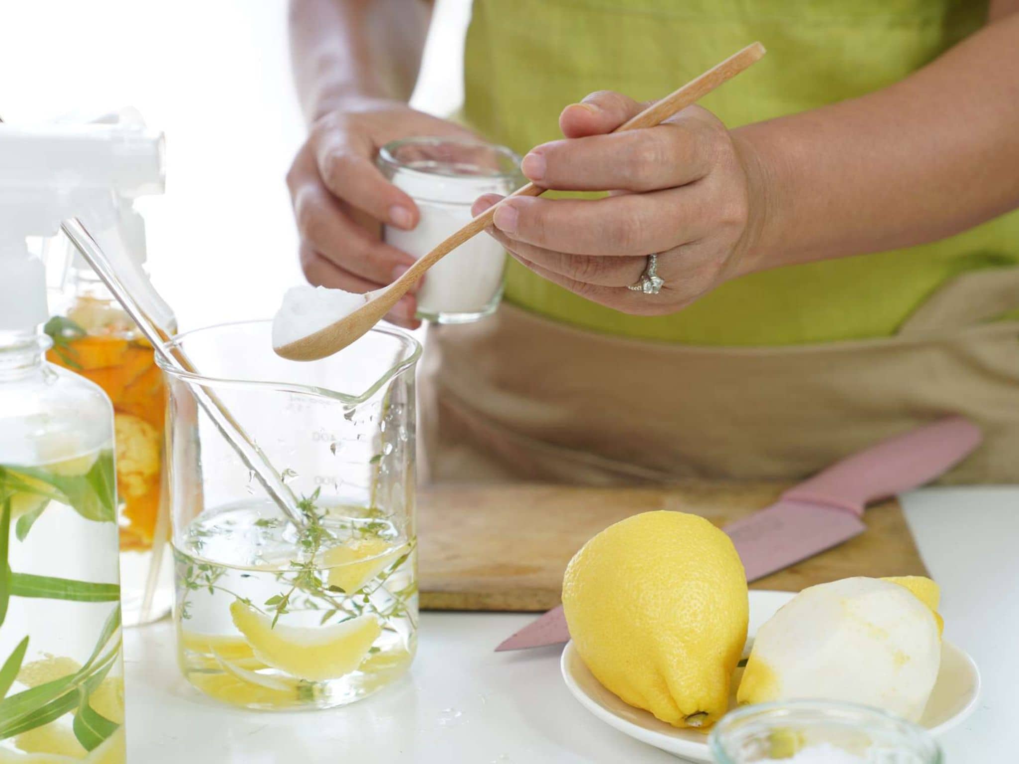 Reinigungsmittel selbst herstellen: Frau stellt in ihrer Küche selber Putzmittel her.