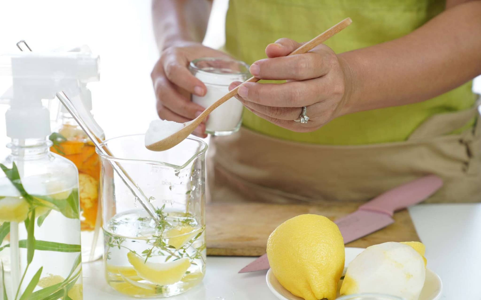 Reinigungsmittel selbst herstellen: Frau stellt in ihrer Küche selber Putzmittel her.